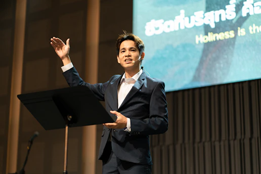 A man in a suit speaks on a stage.
