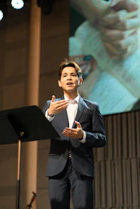 A man in a suit speaking at a podium