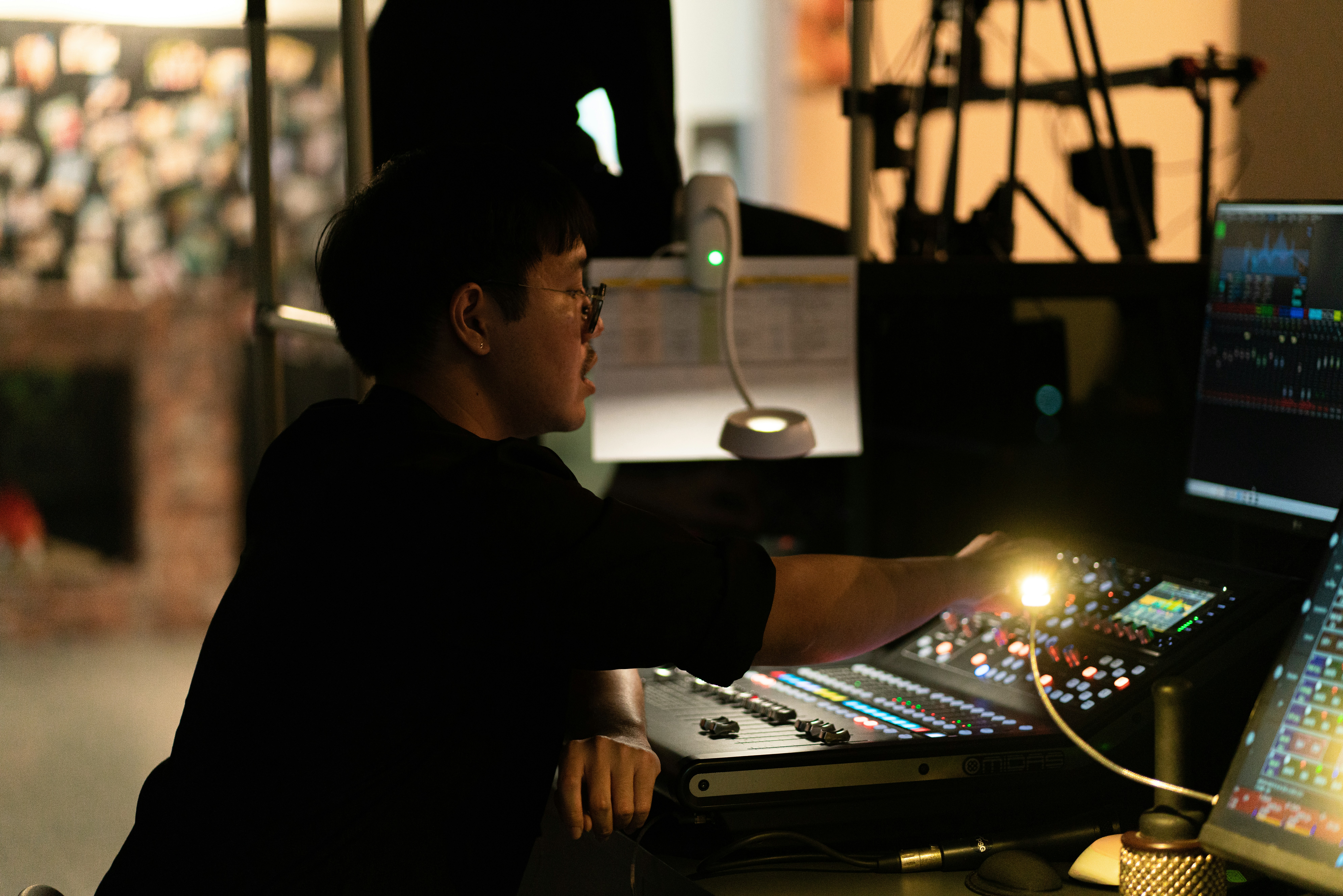 A person adjusting controls on a sound mixing board.