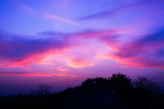 Vibrant purple and pink clouds in the sky at dusk.