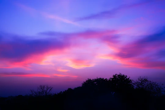 Vibrant purple and pink clouds in the sky at dusk.