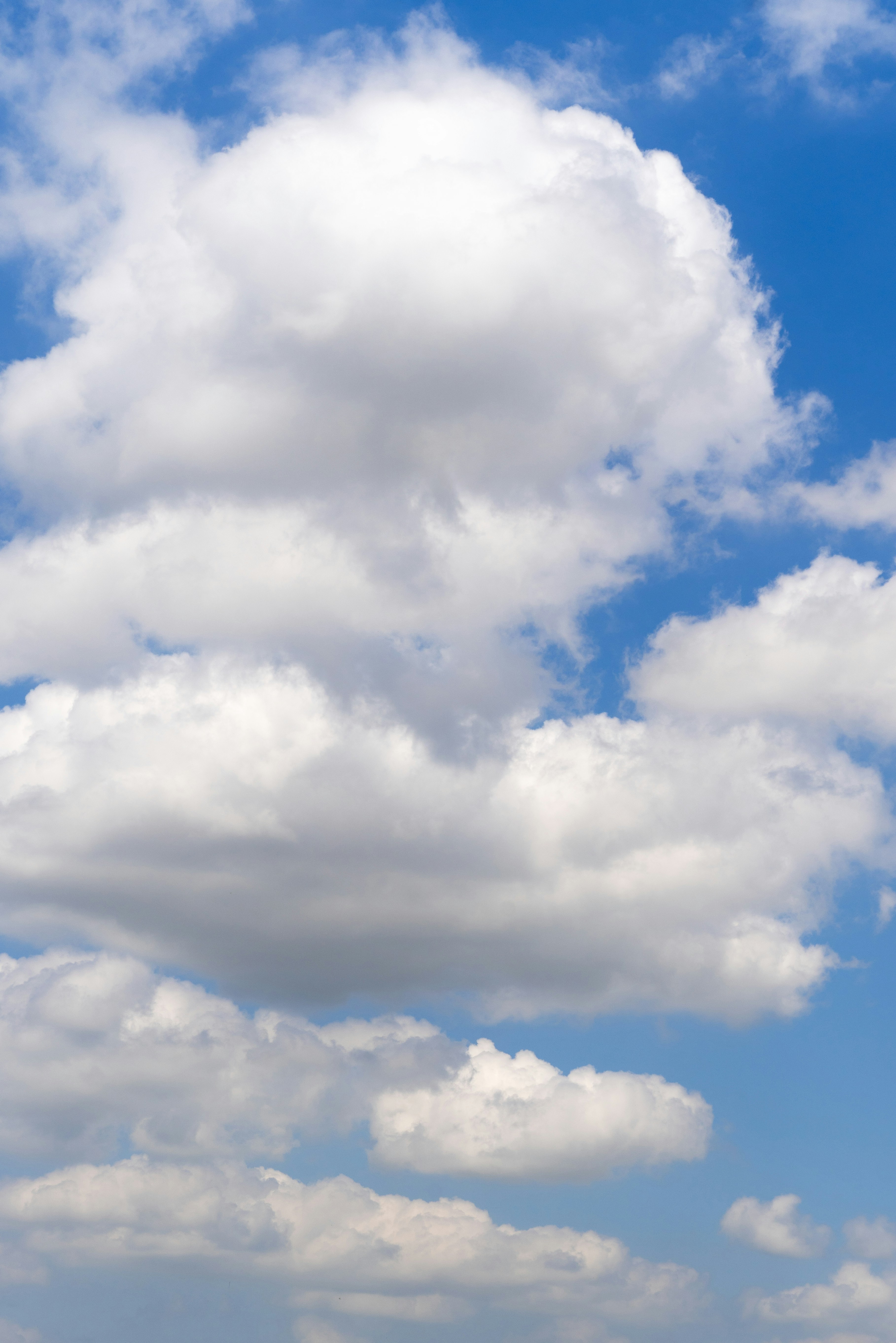Fluffy white clouds against a bright blue sky
