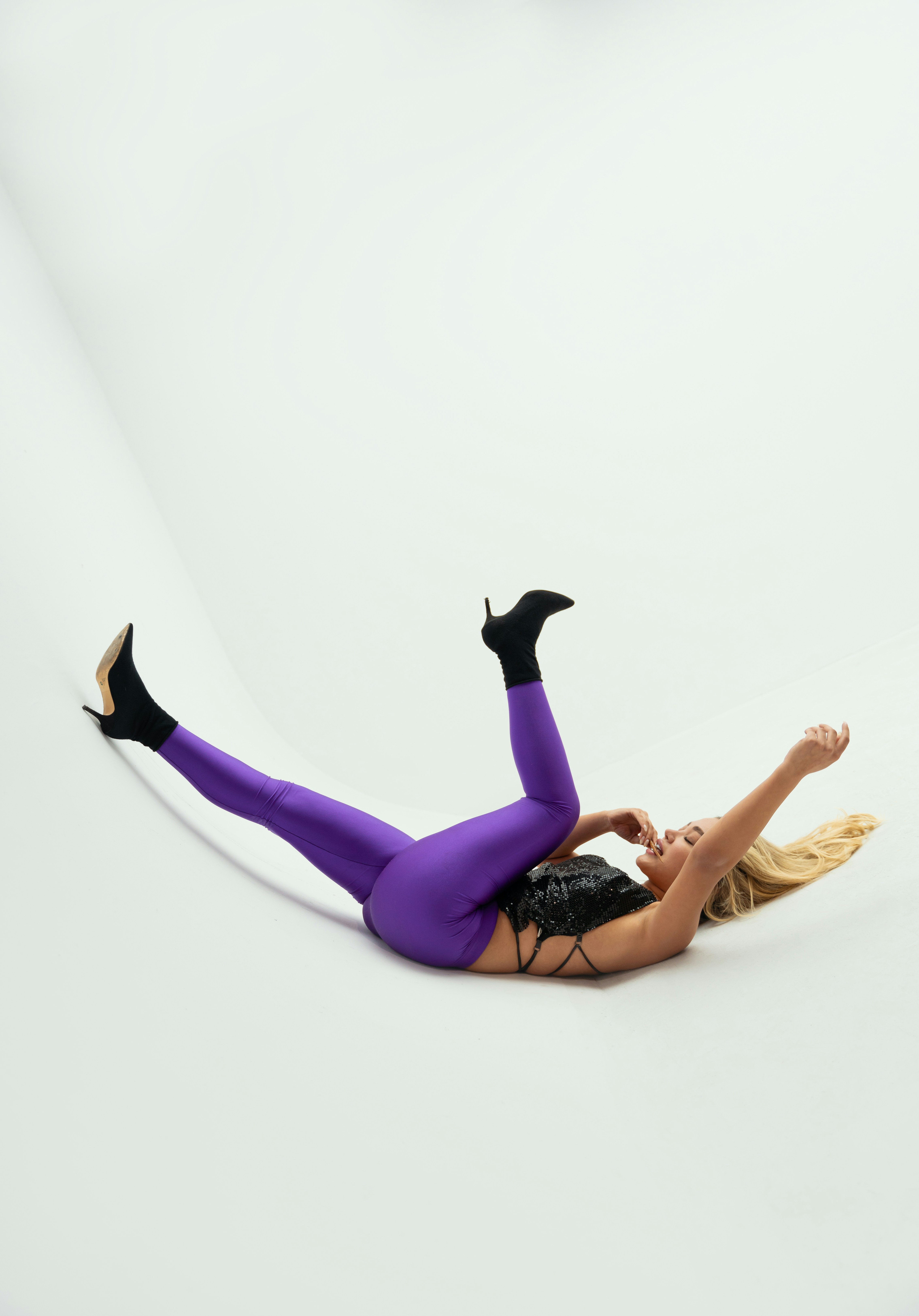 Woman in purple leggings and black top lying down
