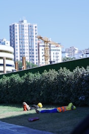 Construction workers resting on grass with buildings behind