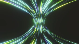Abstract streaks of light converge in a dark space.