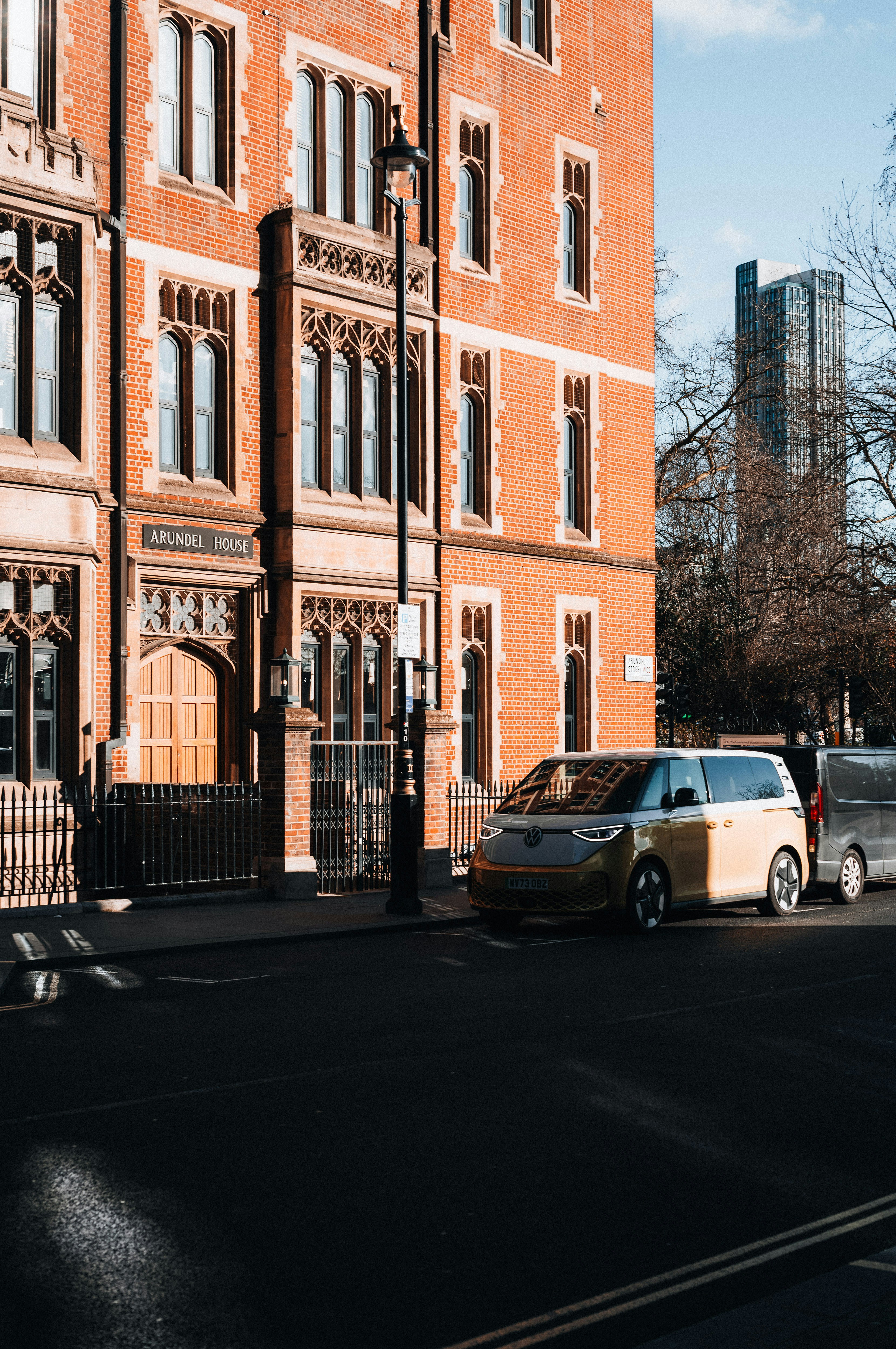 Yellow electric van parked on a city street.