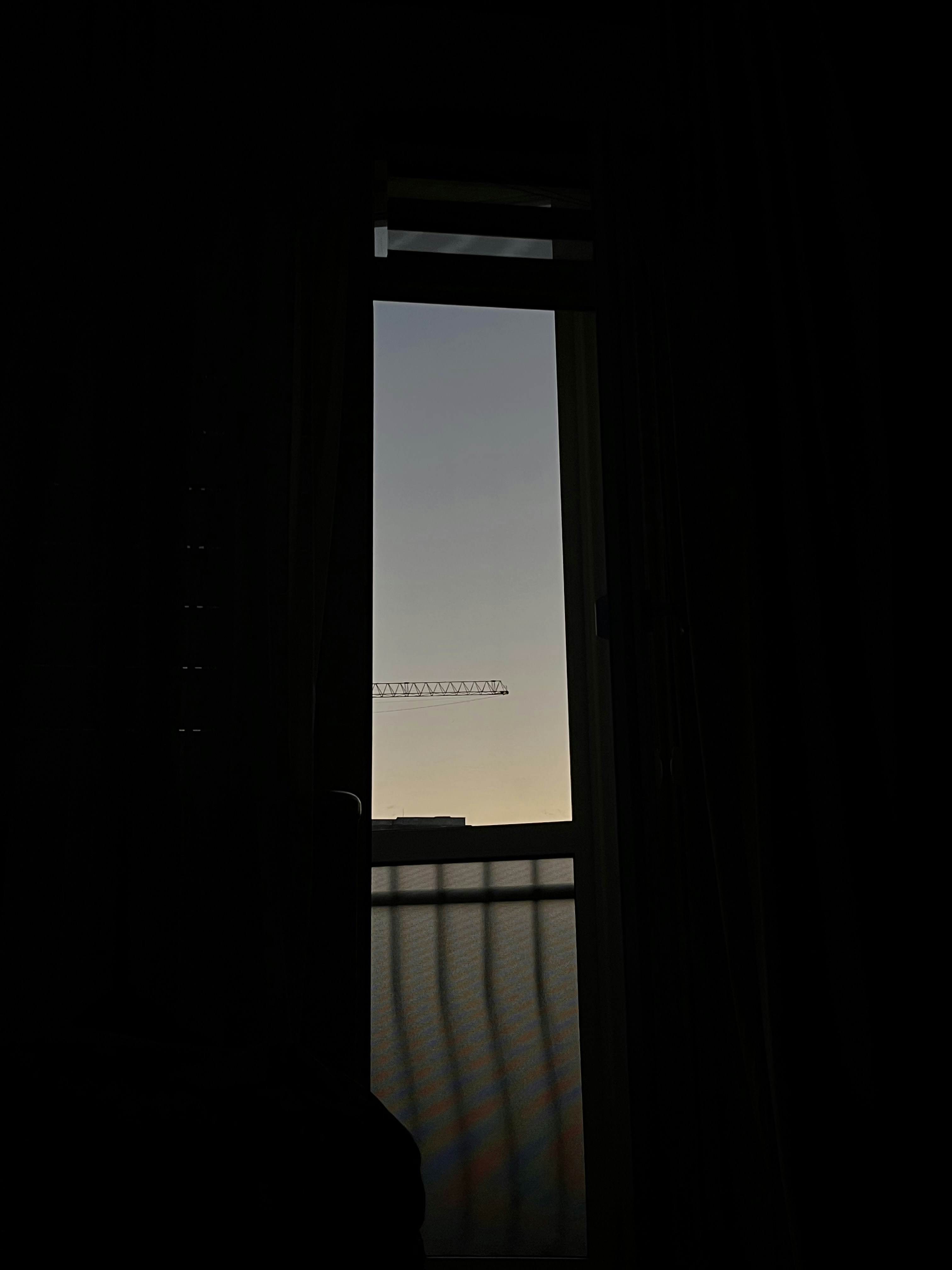 View of a crane through a window at dusk.
