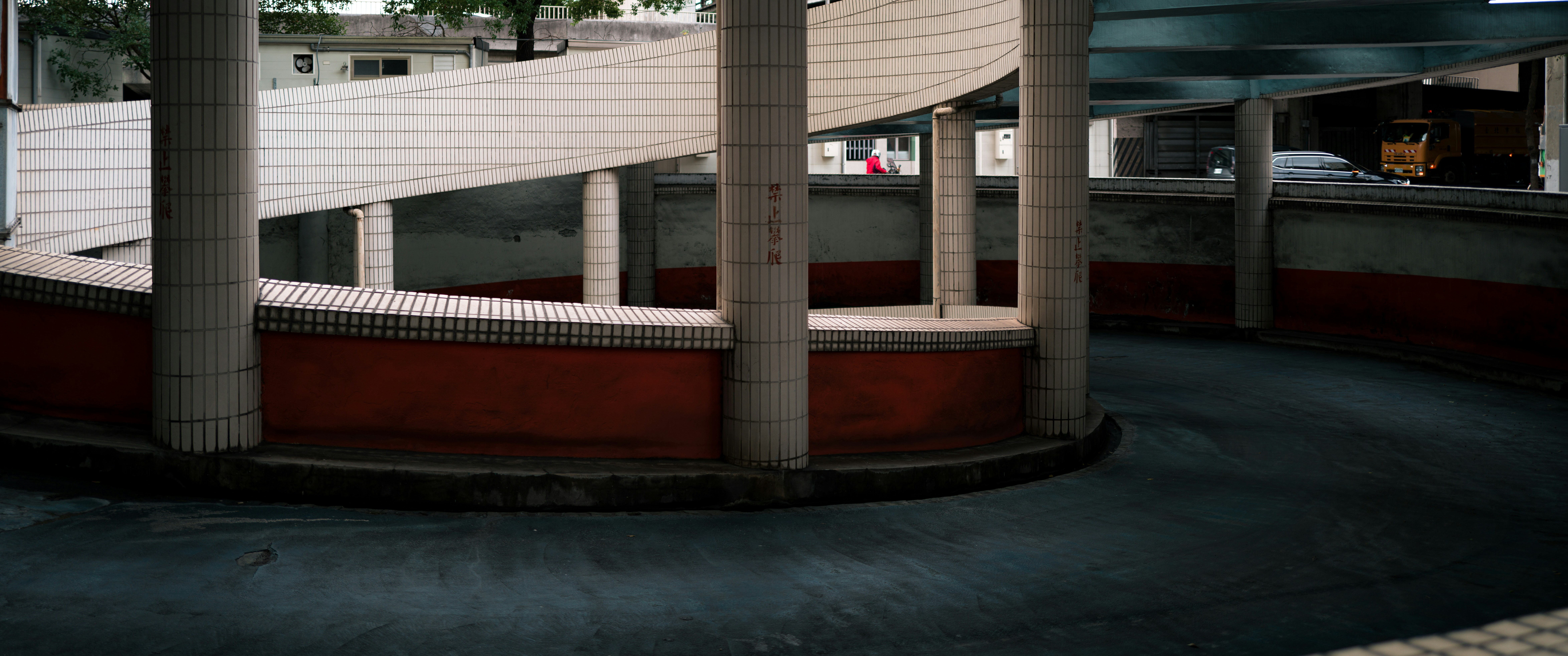Spiral ramp with concrete columns and red wall