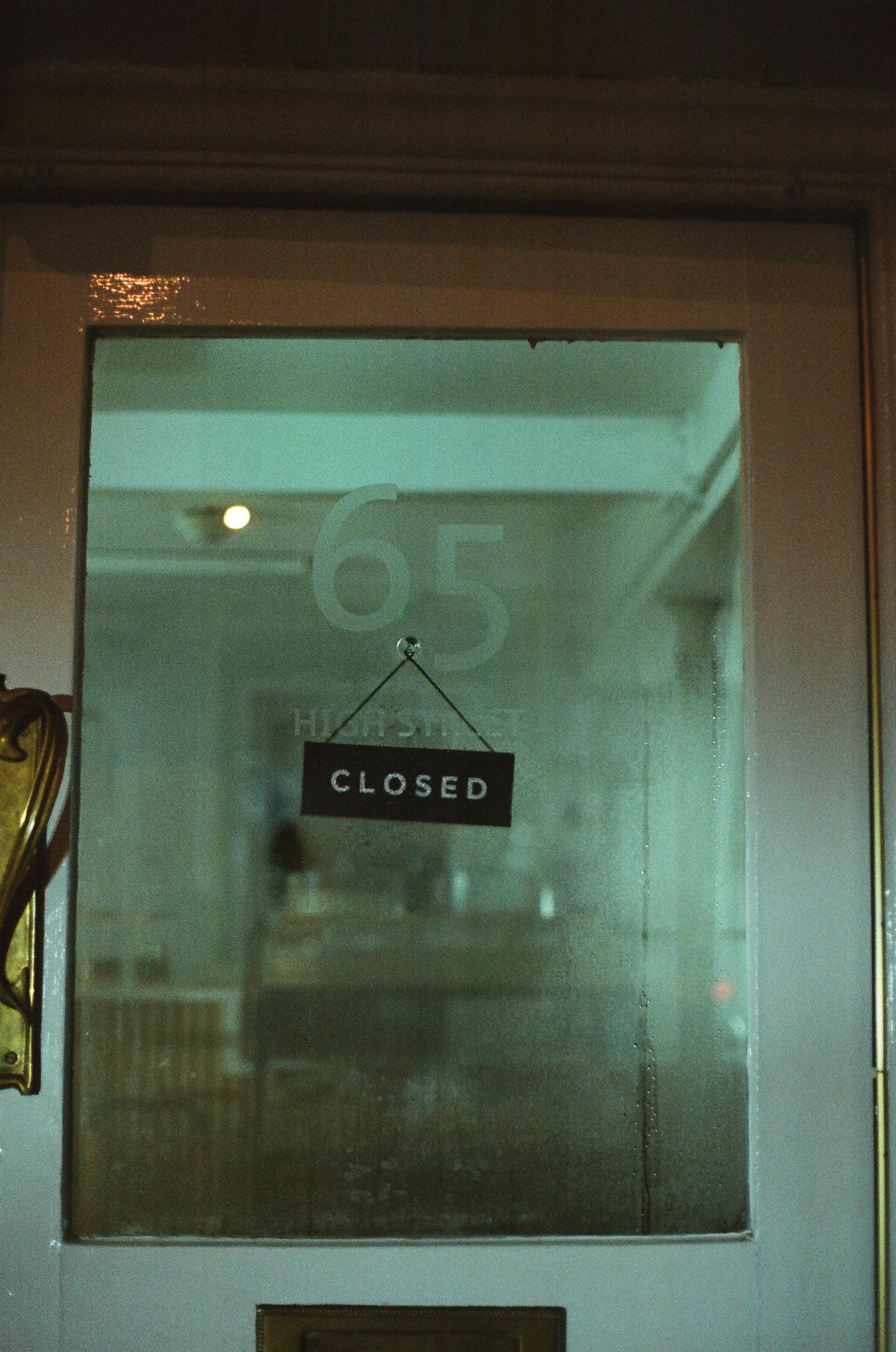 A sign on a glass door reads closed.