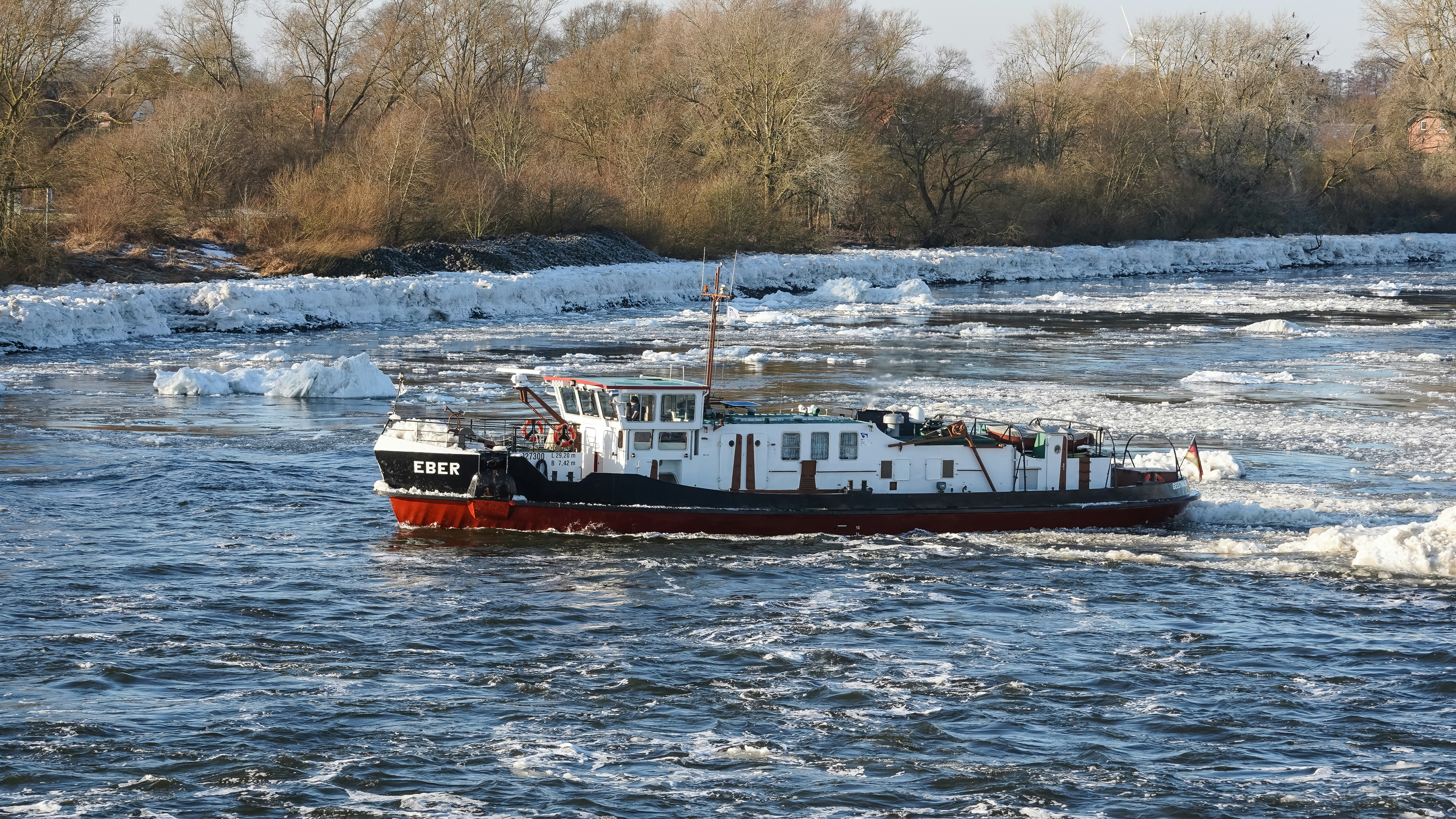 A boat navigates through icy river water