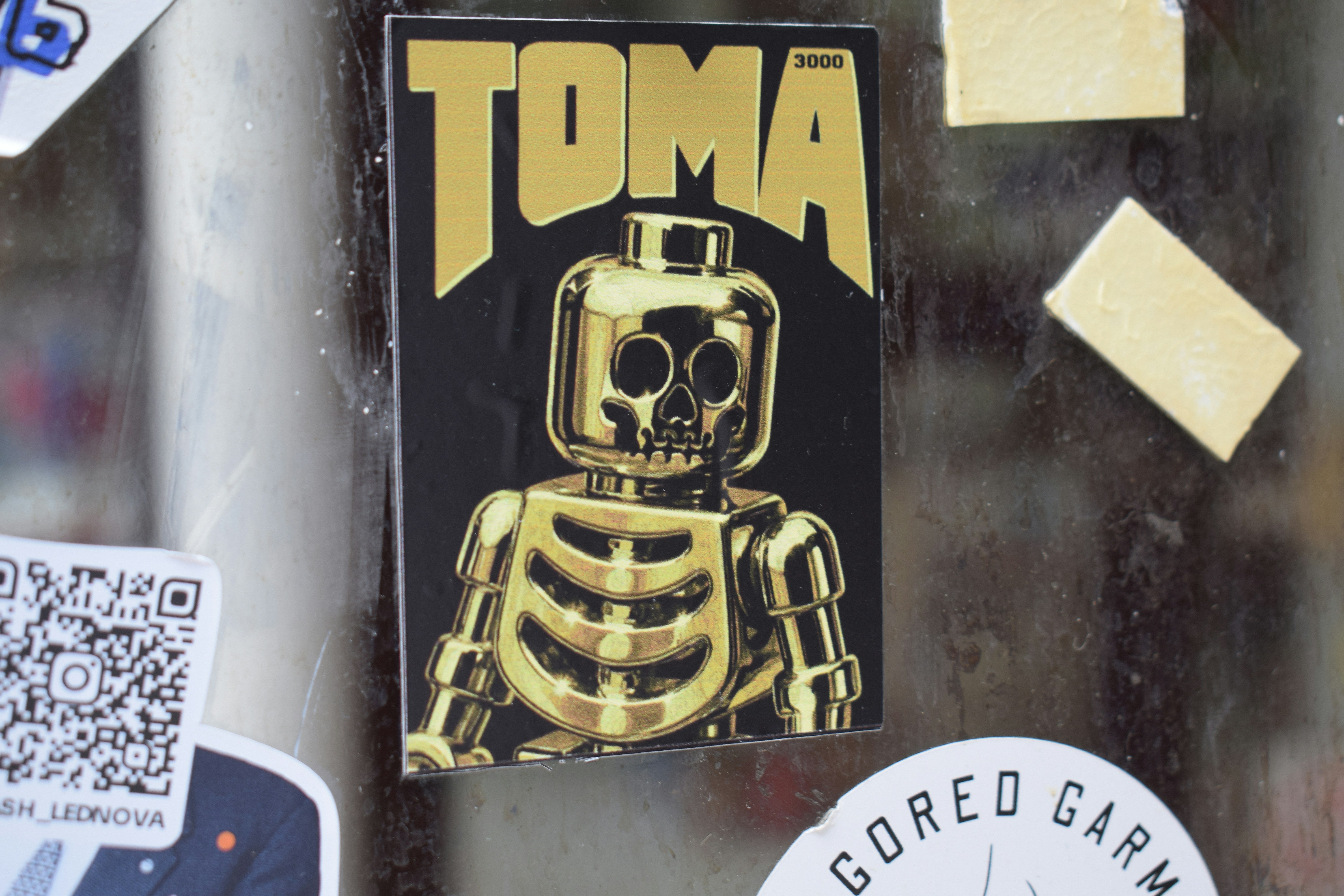 Gold skeleton sticker with "toma" text