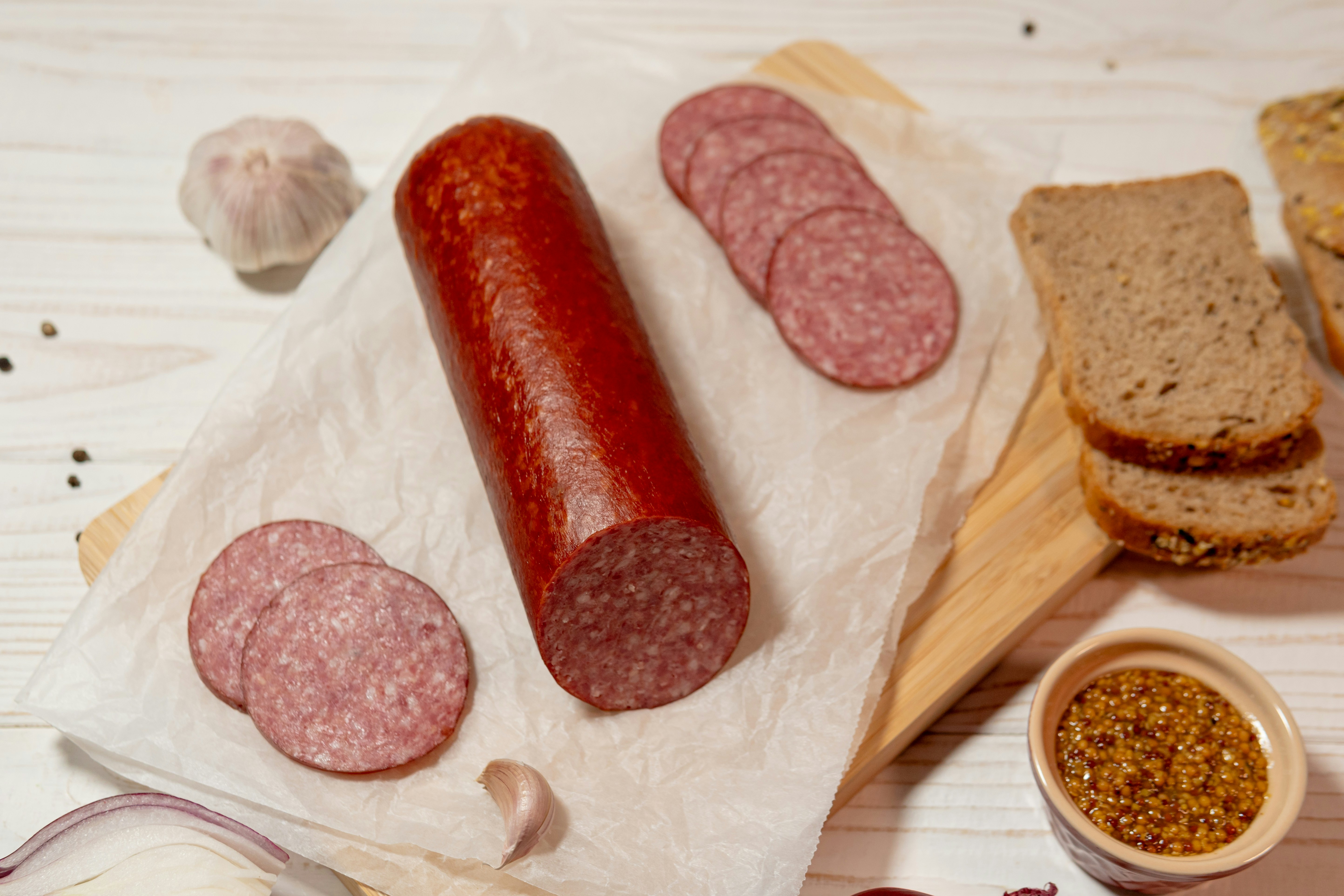 A whole sausage with sliced pieces and bread