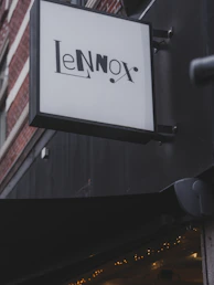 A sign for "le lennox" hangs outside a building