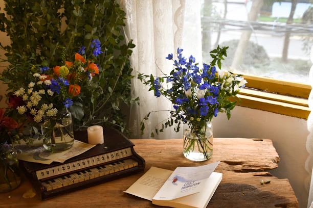 Vase of blue flowers sits on a wooden table.