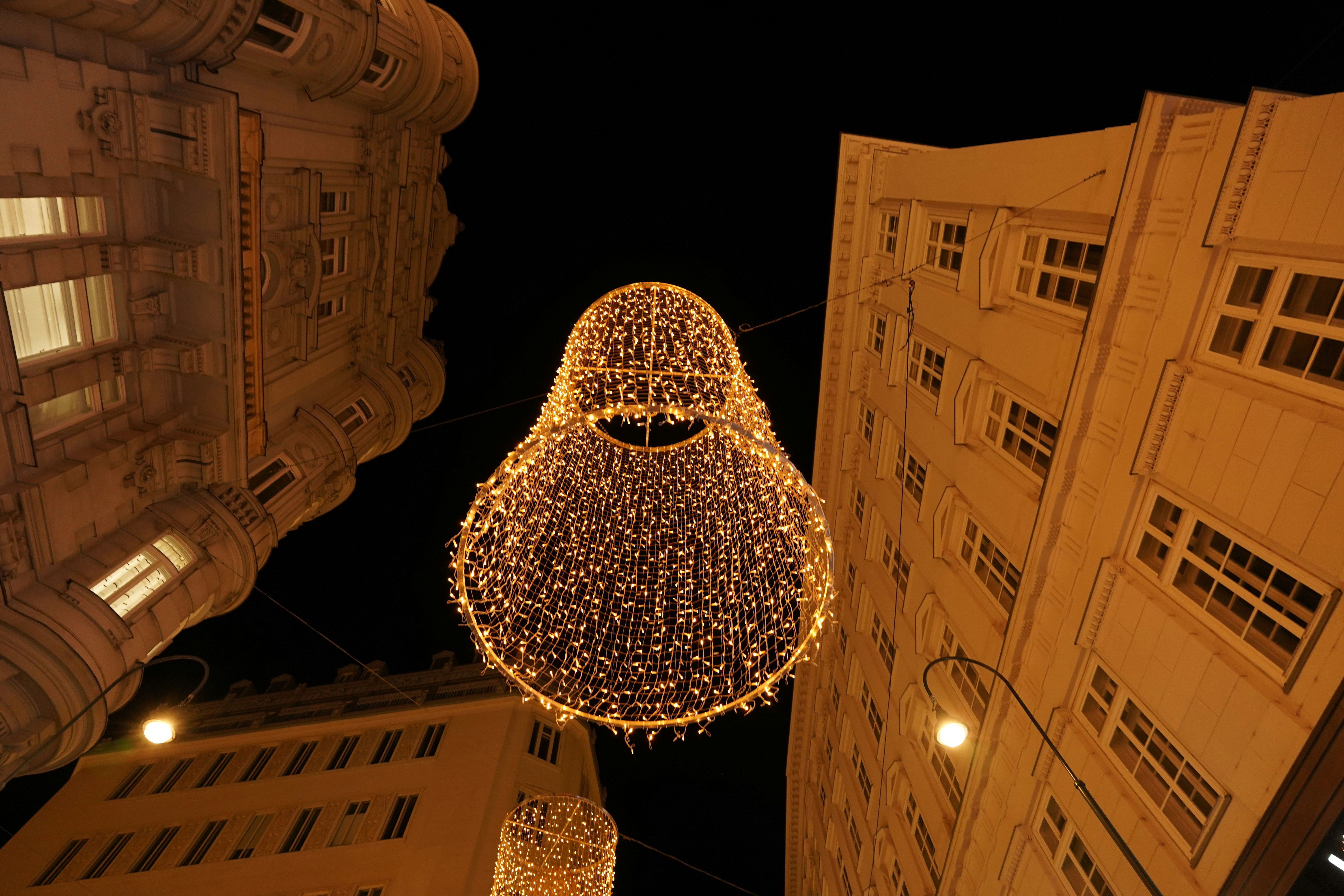 Ornate string lights illuminate a city street at night.