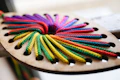 Colorful ropes threaded through wooden shape