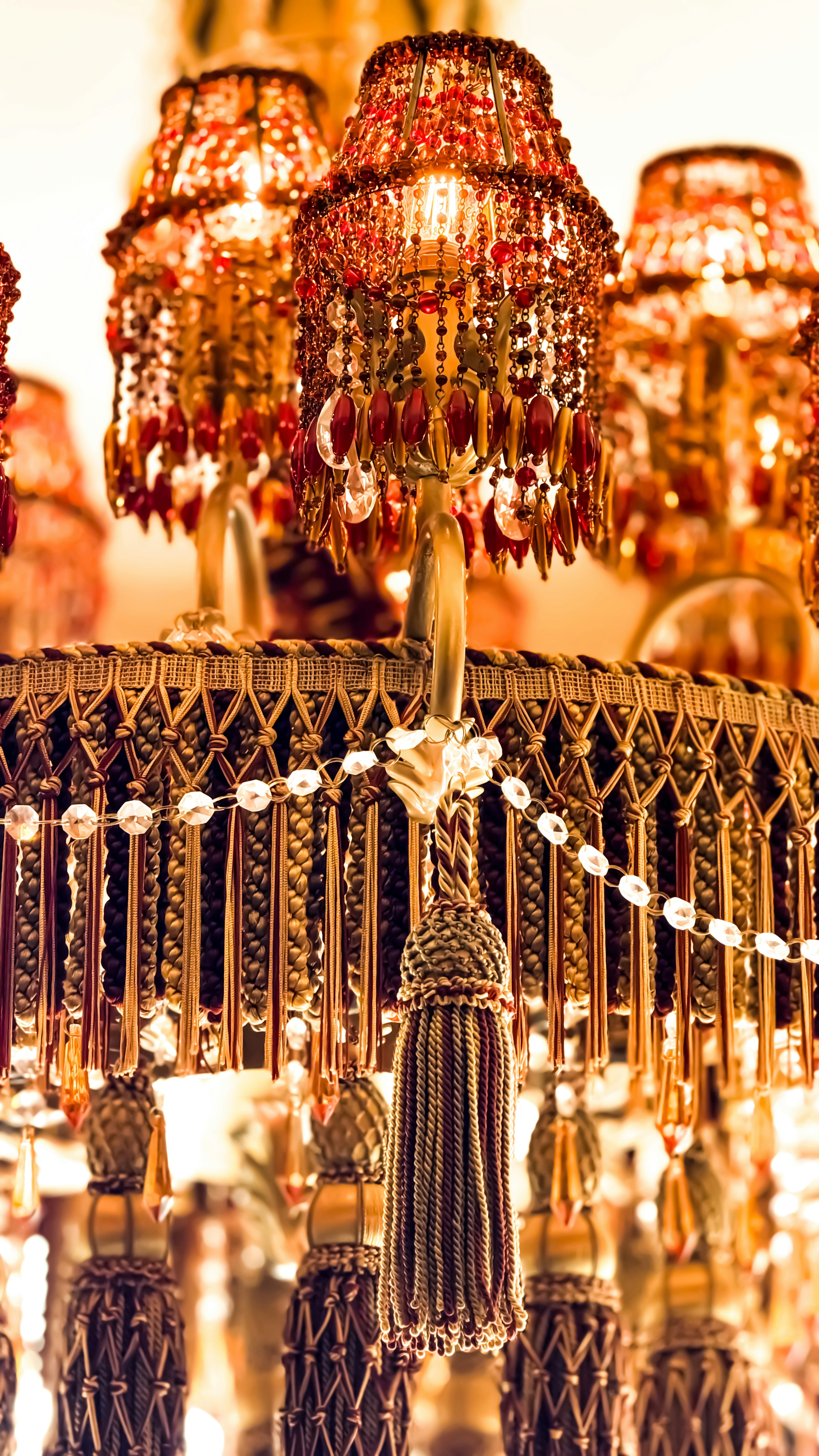 Ornate chandelier with beaded lampshades and tassels.