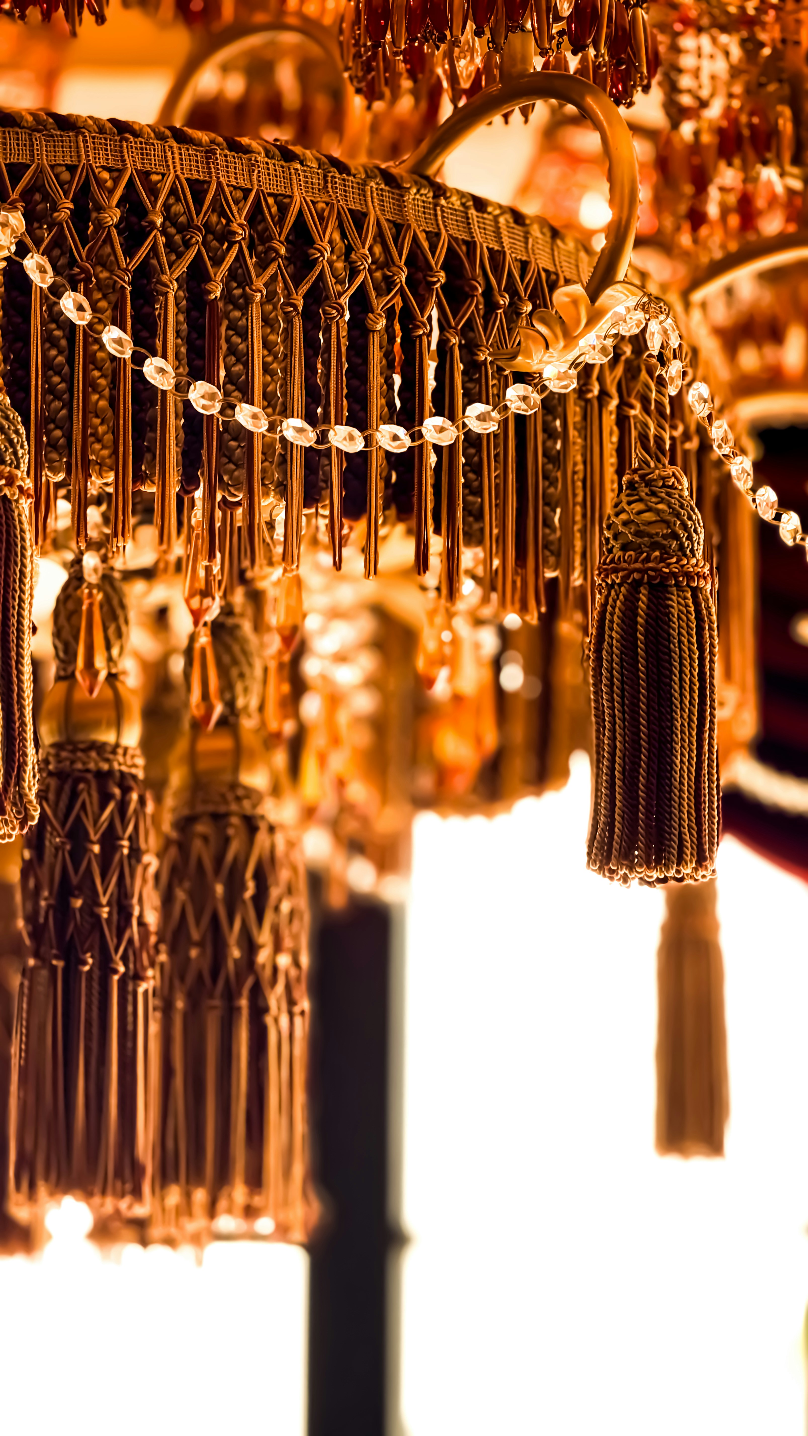 Decorative golden tassels and beads on a chandelier.