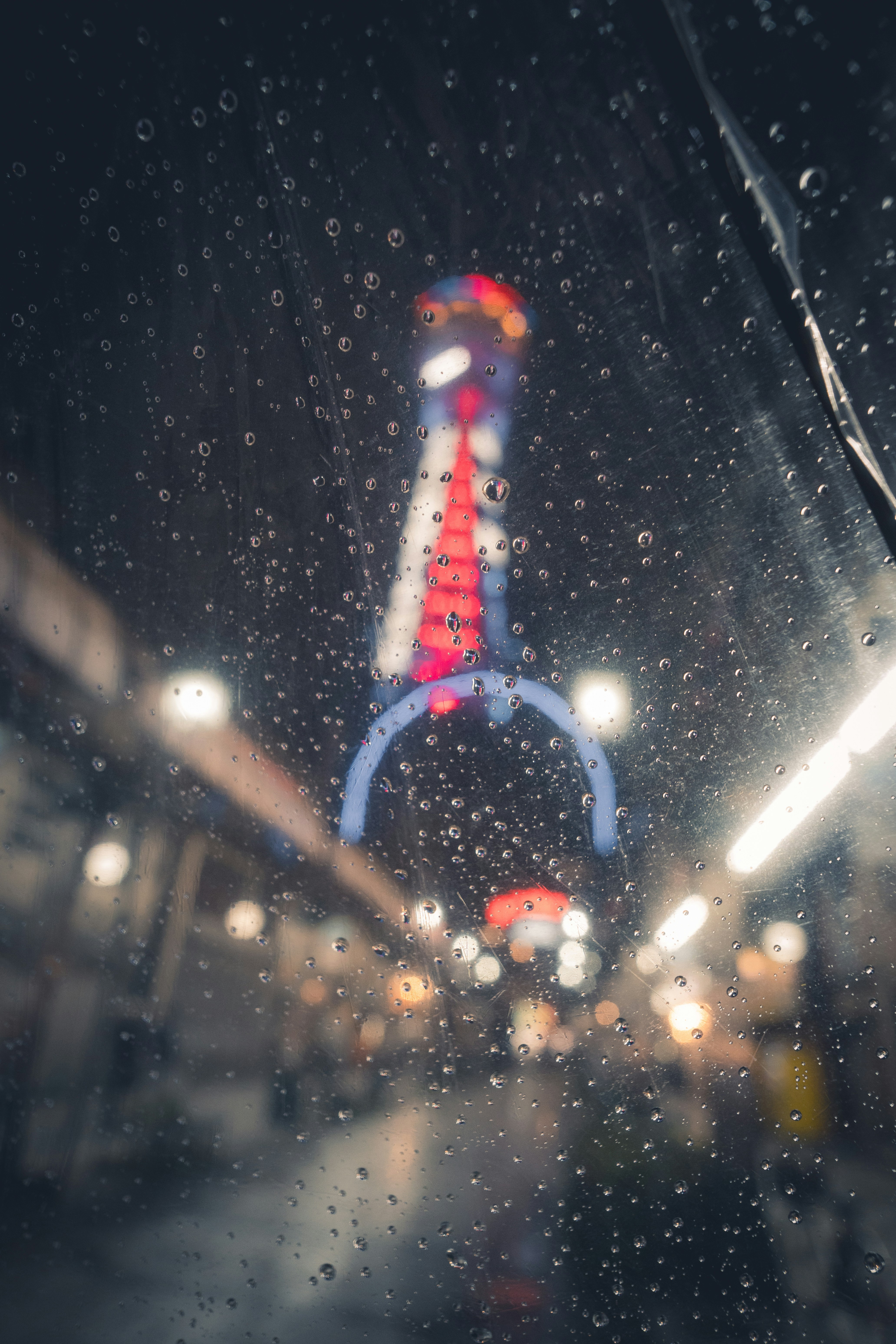 Gotas de chuva na janela com luzes borradas da cidade à noite
