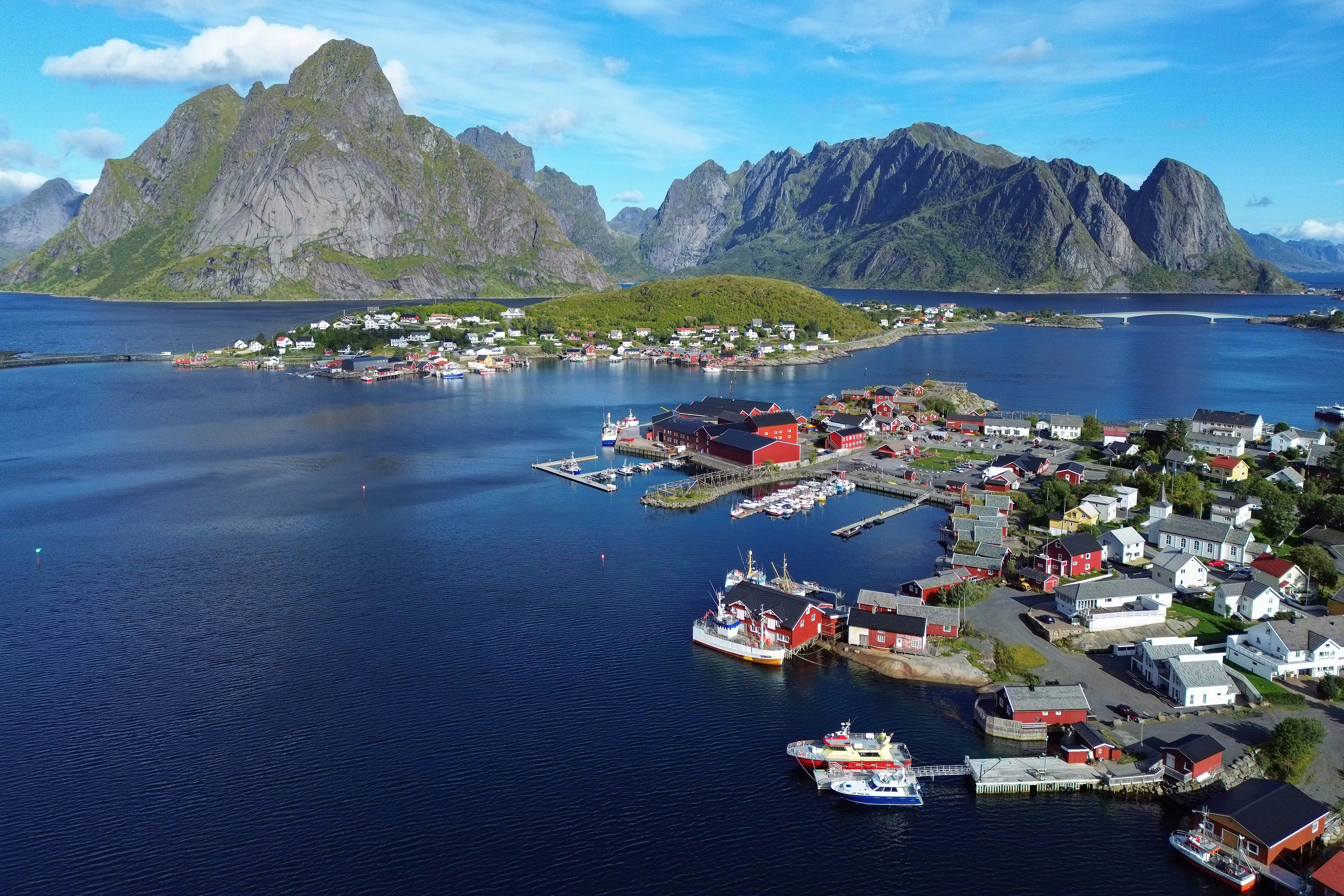 Coastal village with colorful houses and mountains.