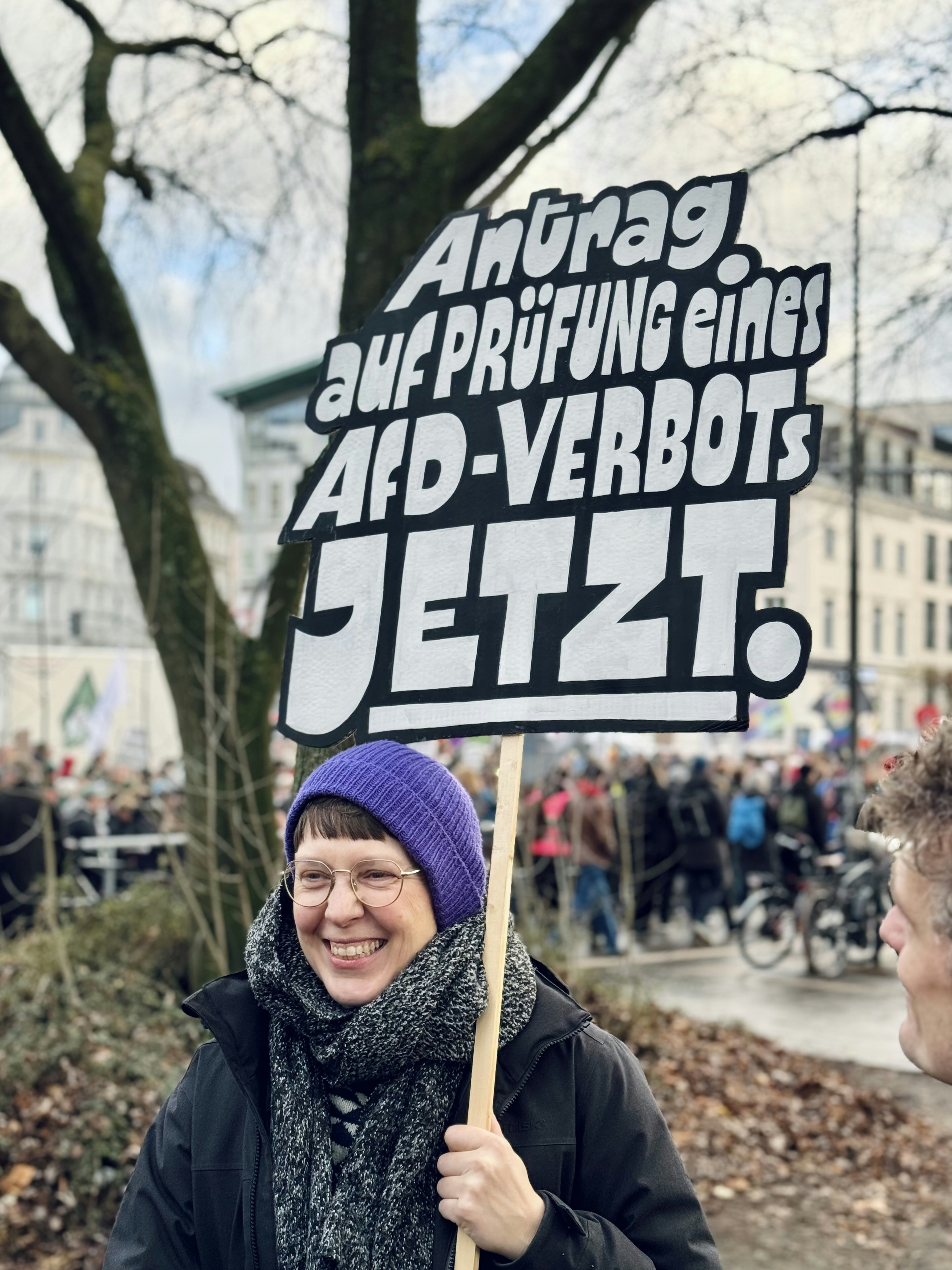 Woman holds sign for afd ban protest