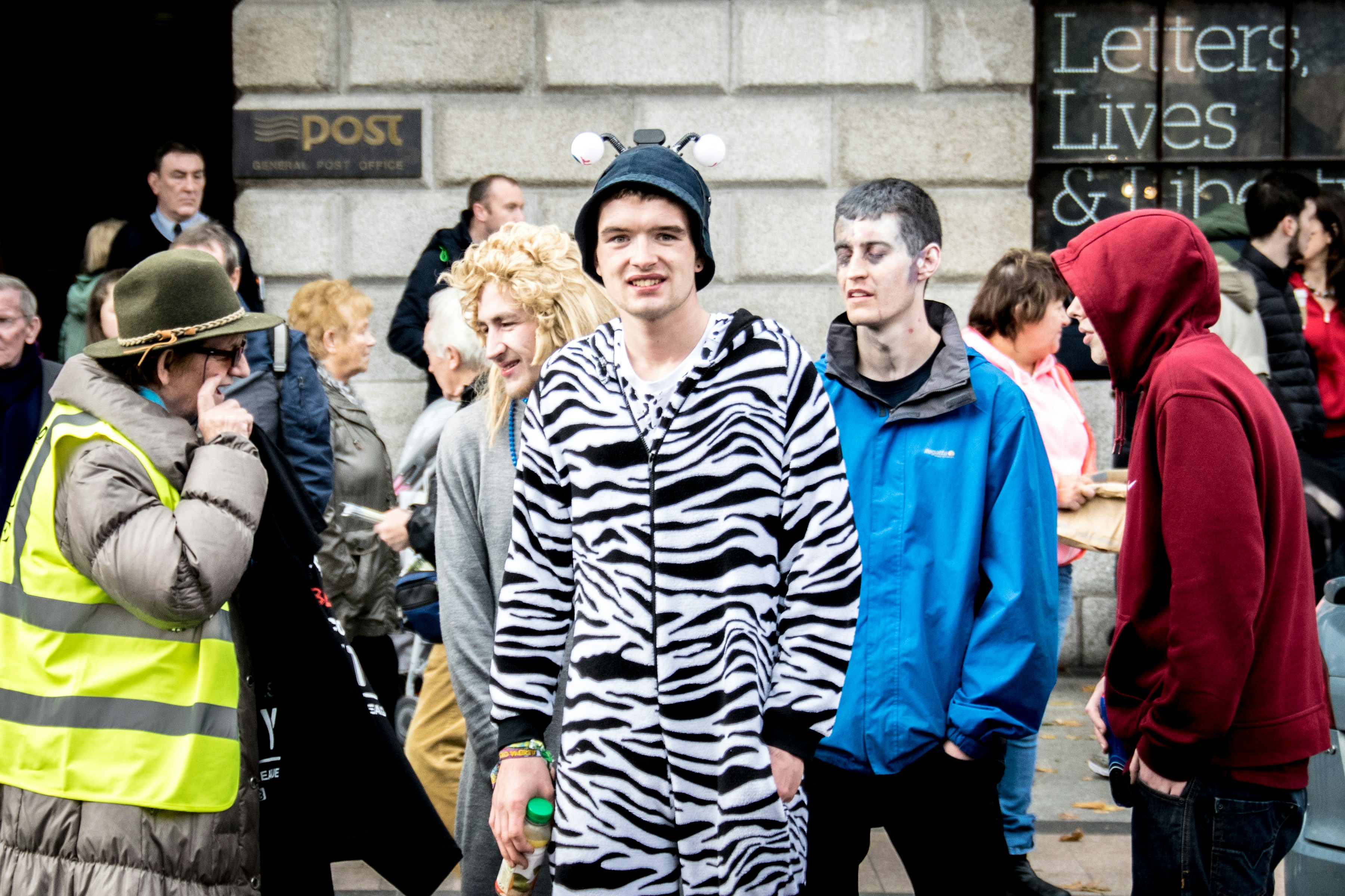 Man in zebra costume standing with people