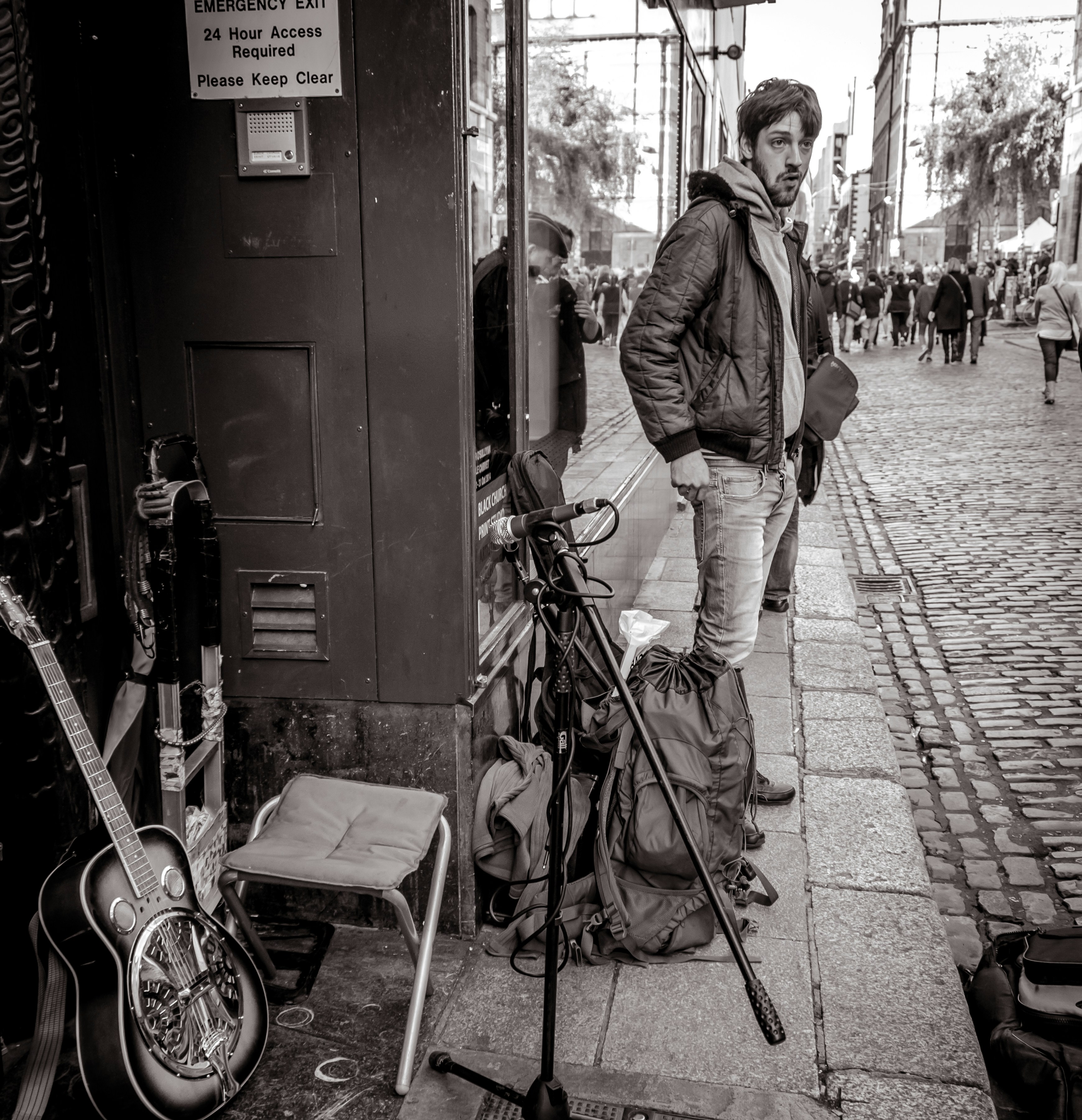 Man with guitar and microphone on street