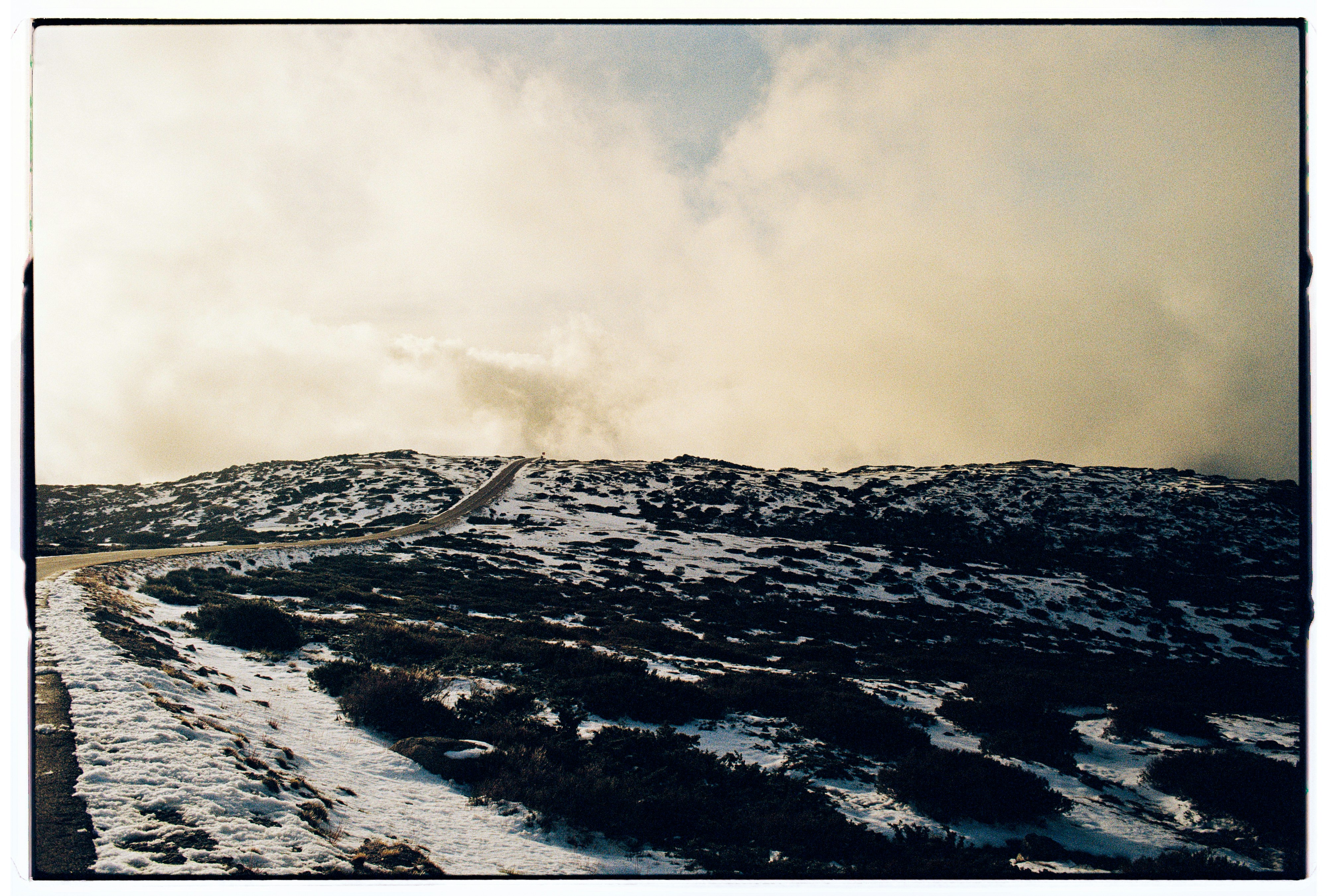 Snowy mountain path under a cloudy sky