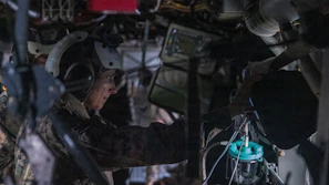 Soldier wearing headset works inside a vehicle