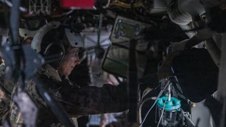 Soldier wearing headset works inside a vehicle
