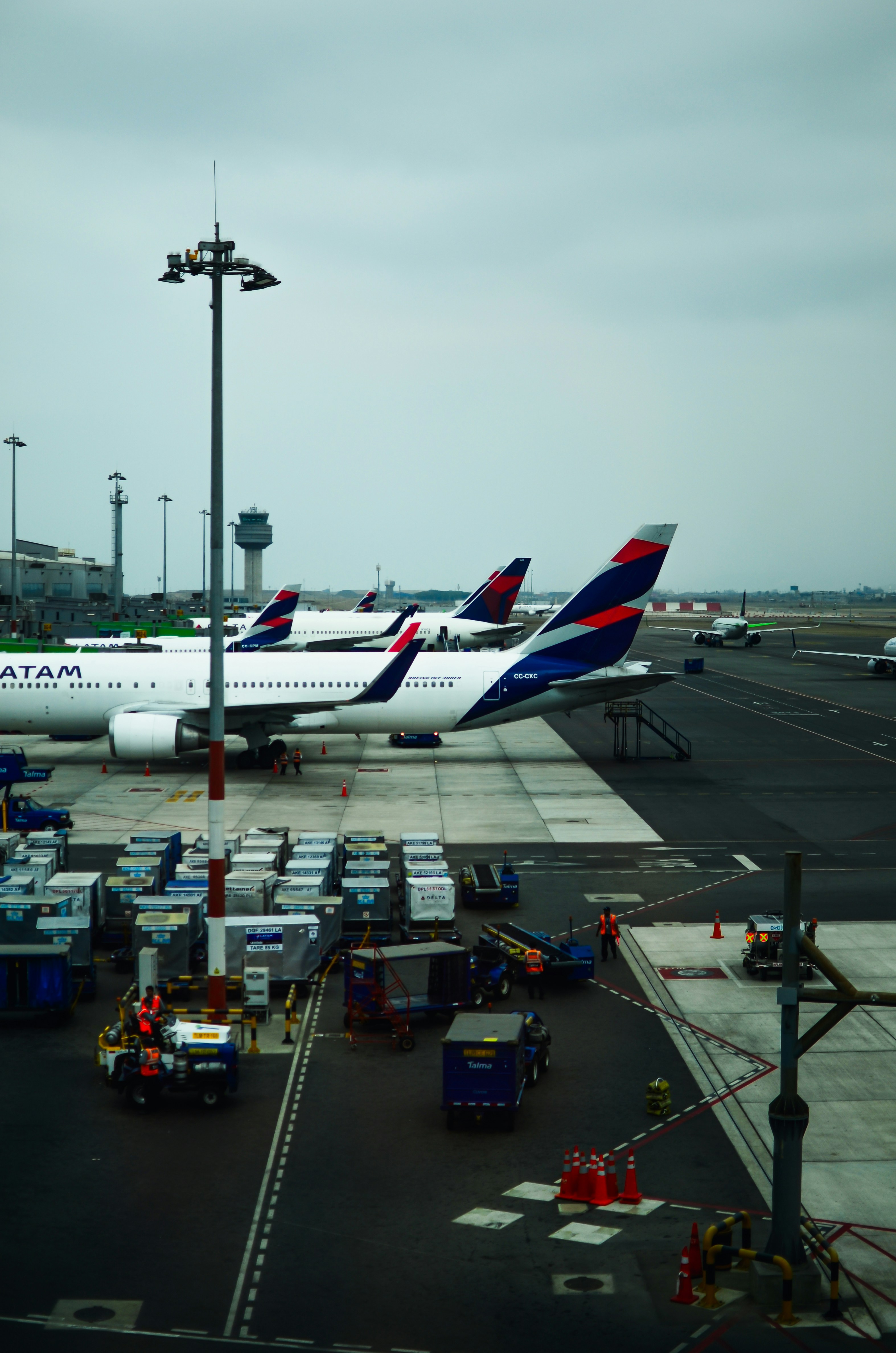 Airplanes parked at airport with luggage carts