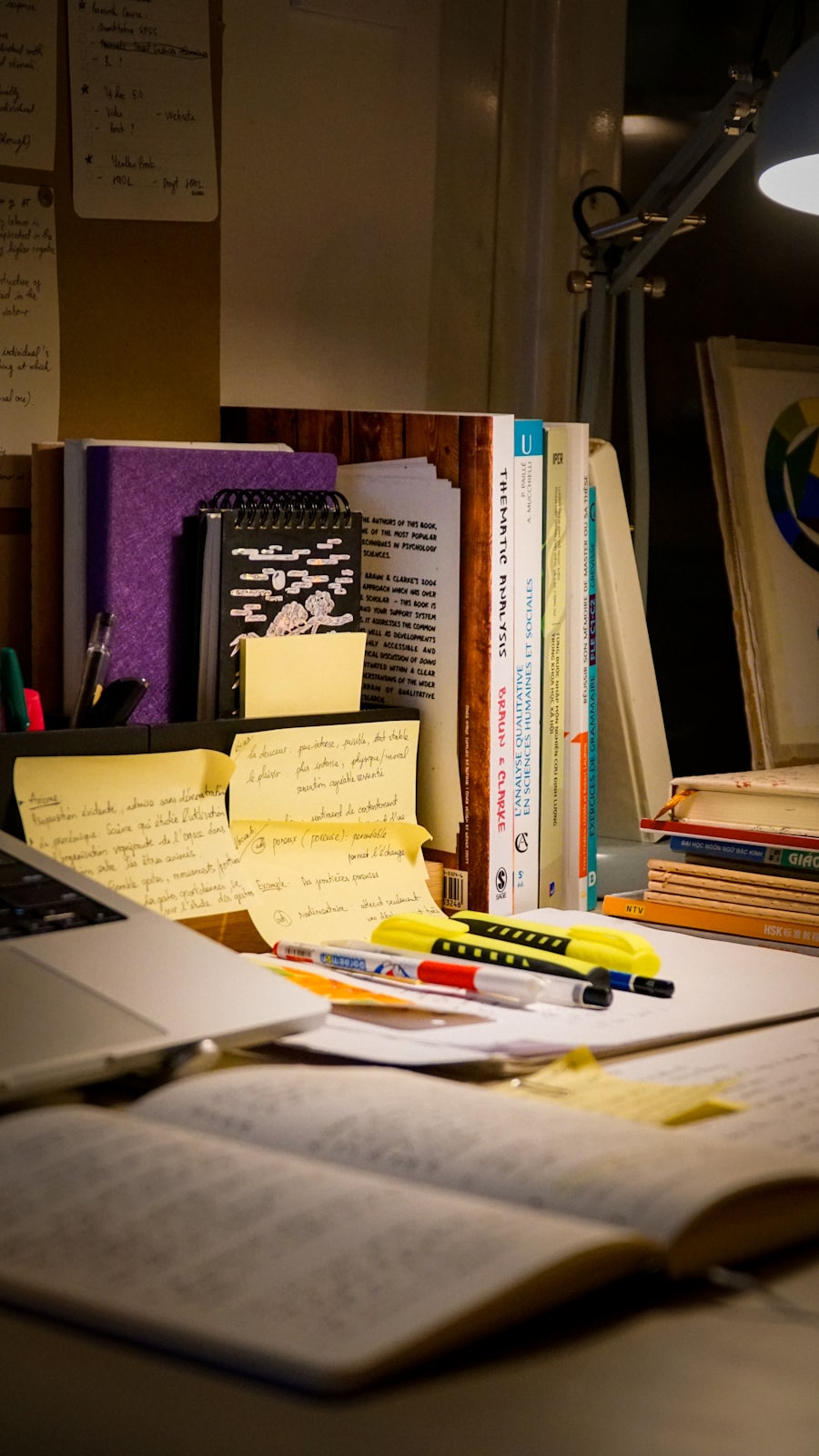 Desk with open notebook, research books, and study materials