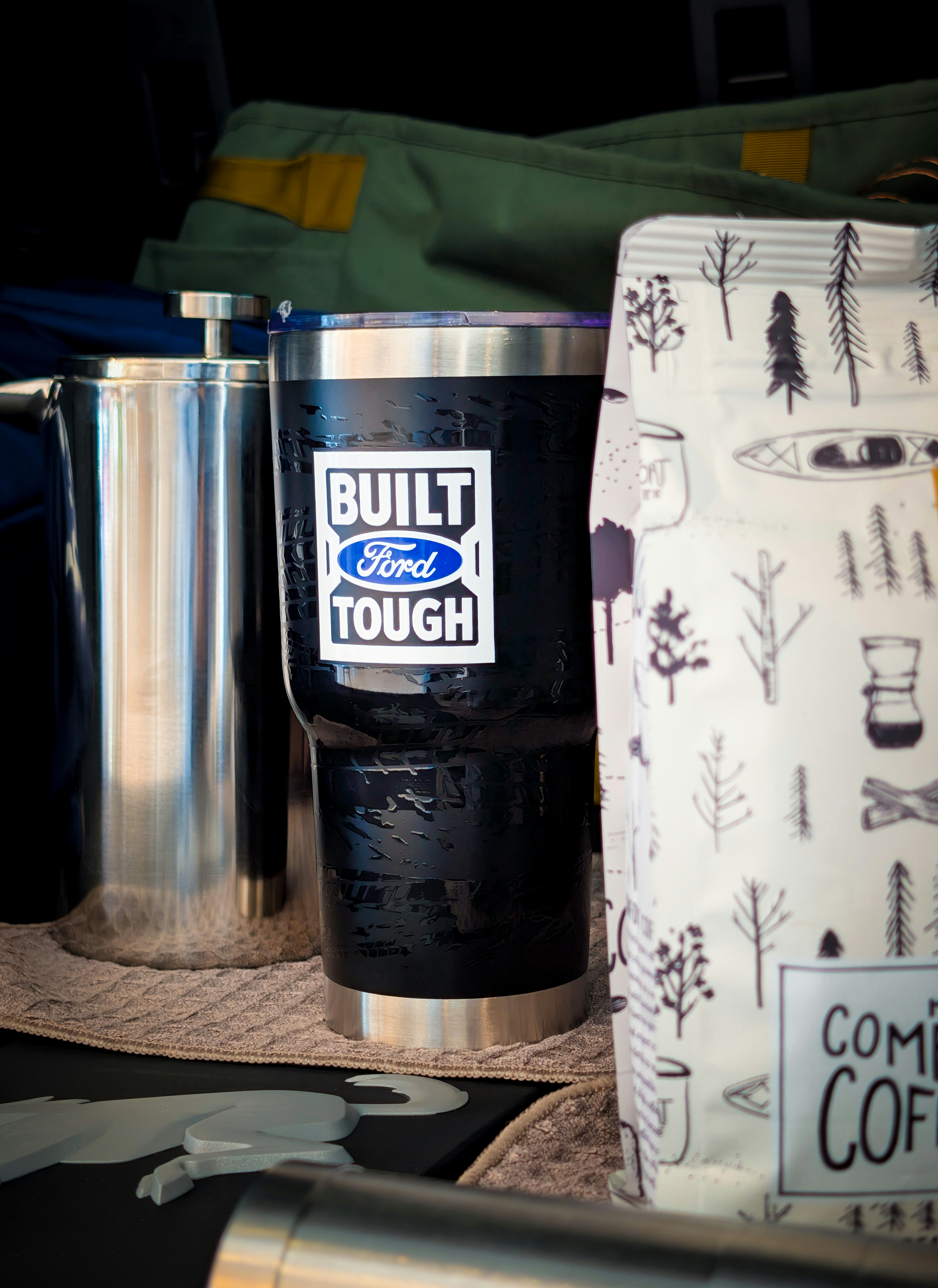 Black tumbler with ford built tough sticker and coffee bag