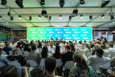 Audience watches a presentation on a large screen.