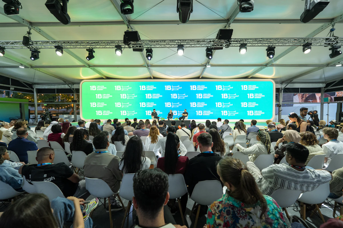 Event audience watching a presentation: sponsor branding on every guest photo generates lasting post-event visibility