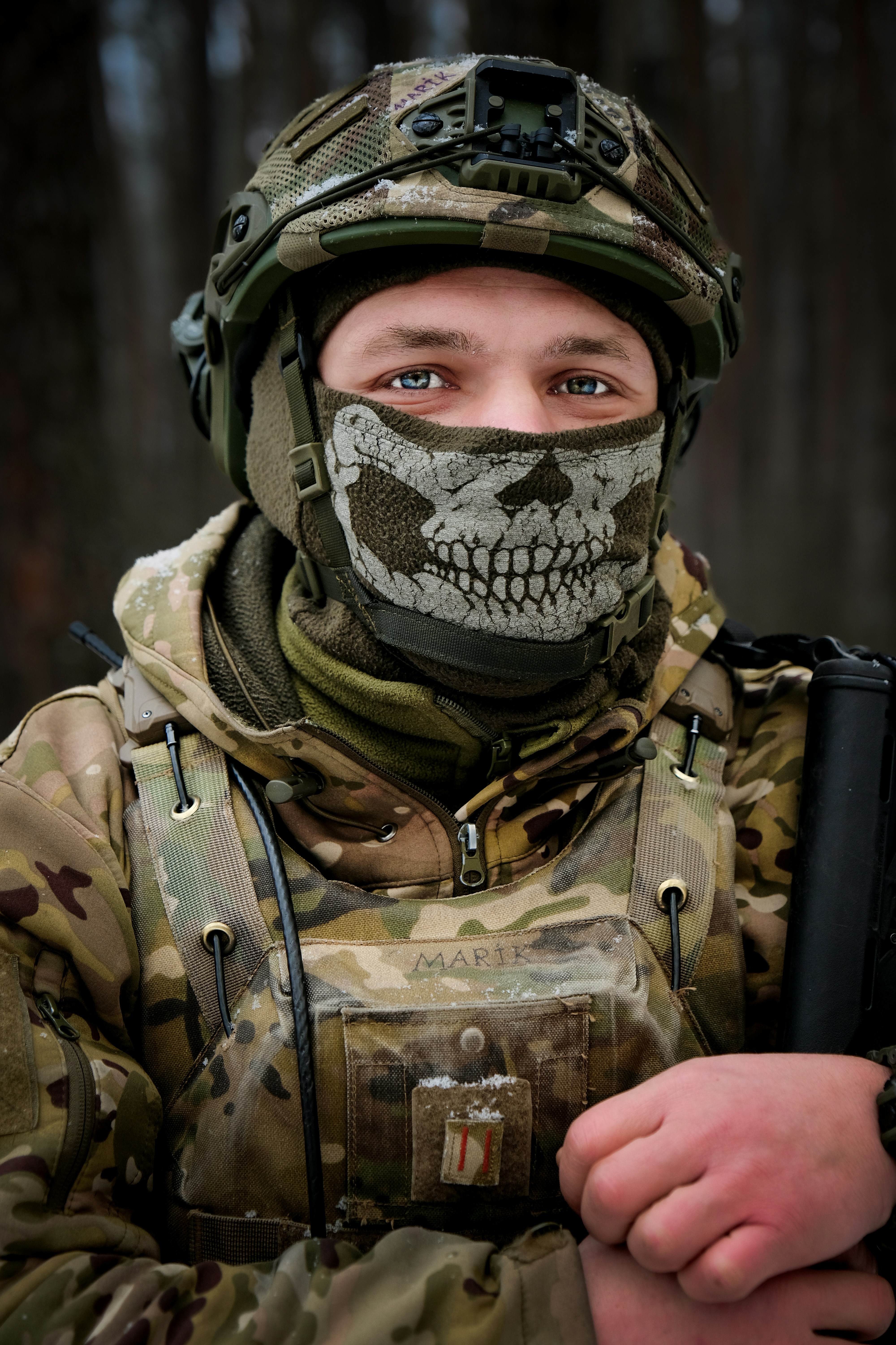 Soldier wearing skull mask and camouflage gear.