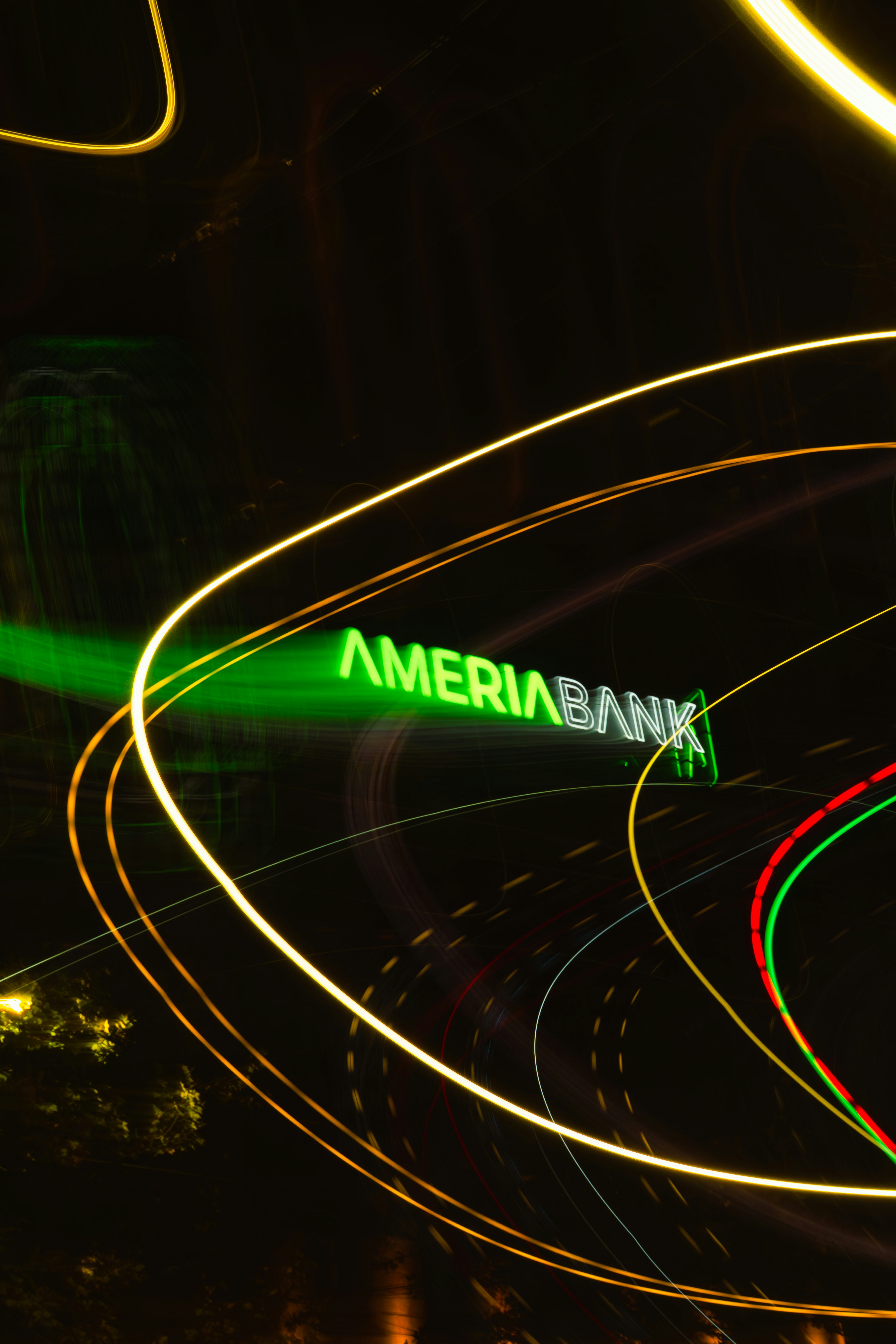 Abstract light trails around a neon ameriabank sign