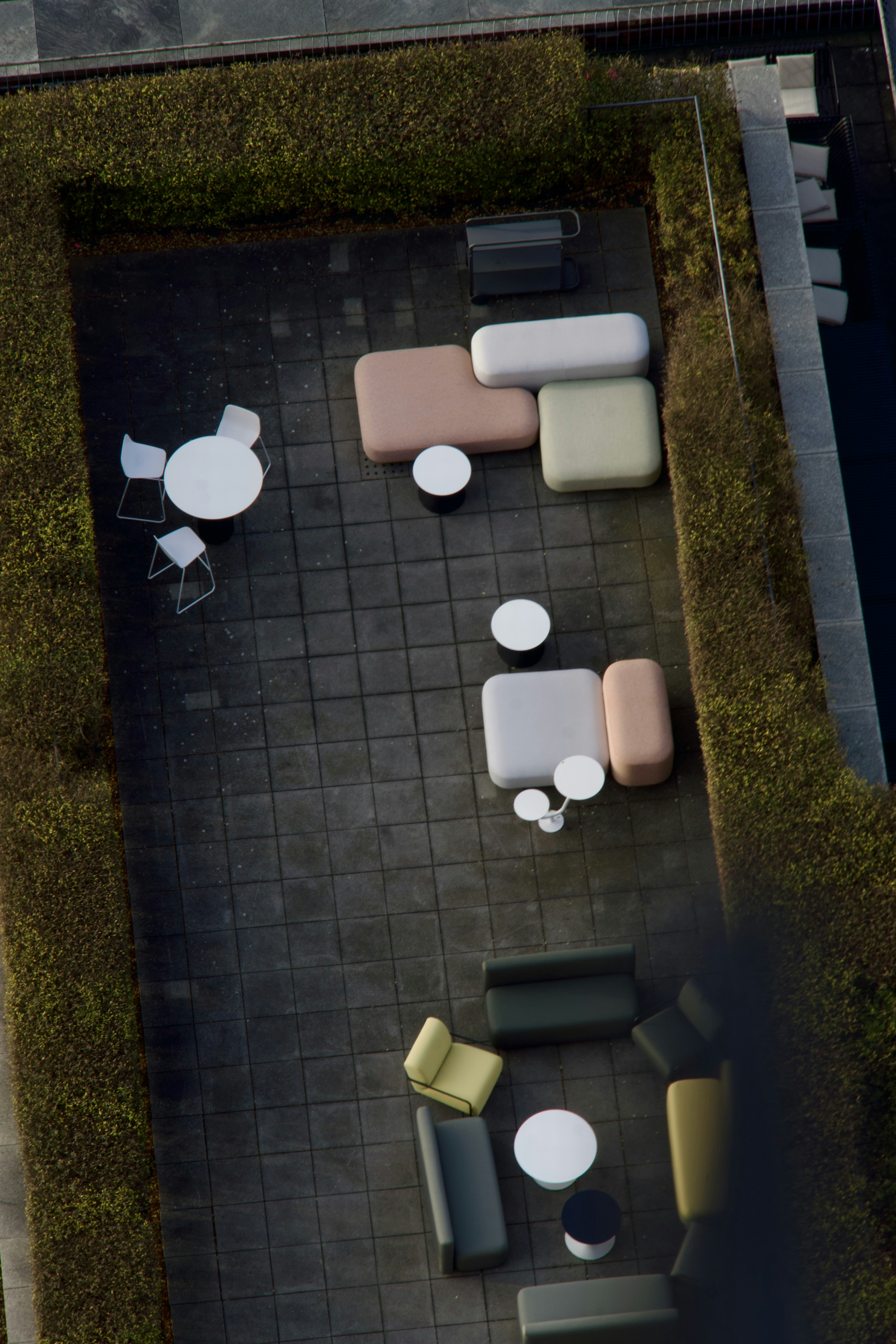 Zona de estar moderna al aire libre con sofás y mesas mullidas.