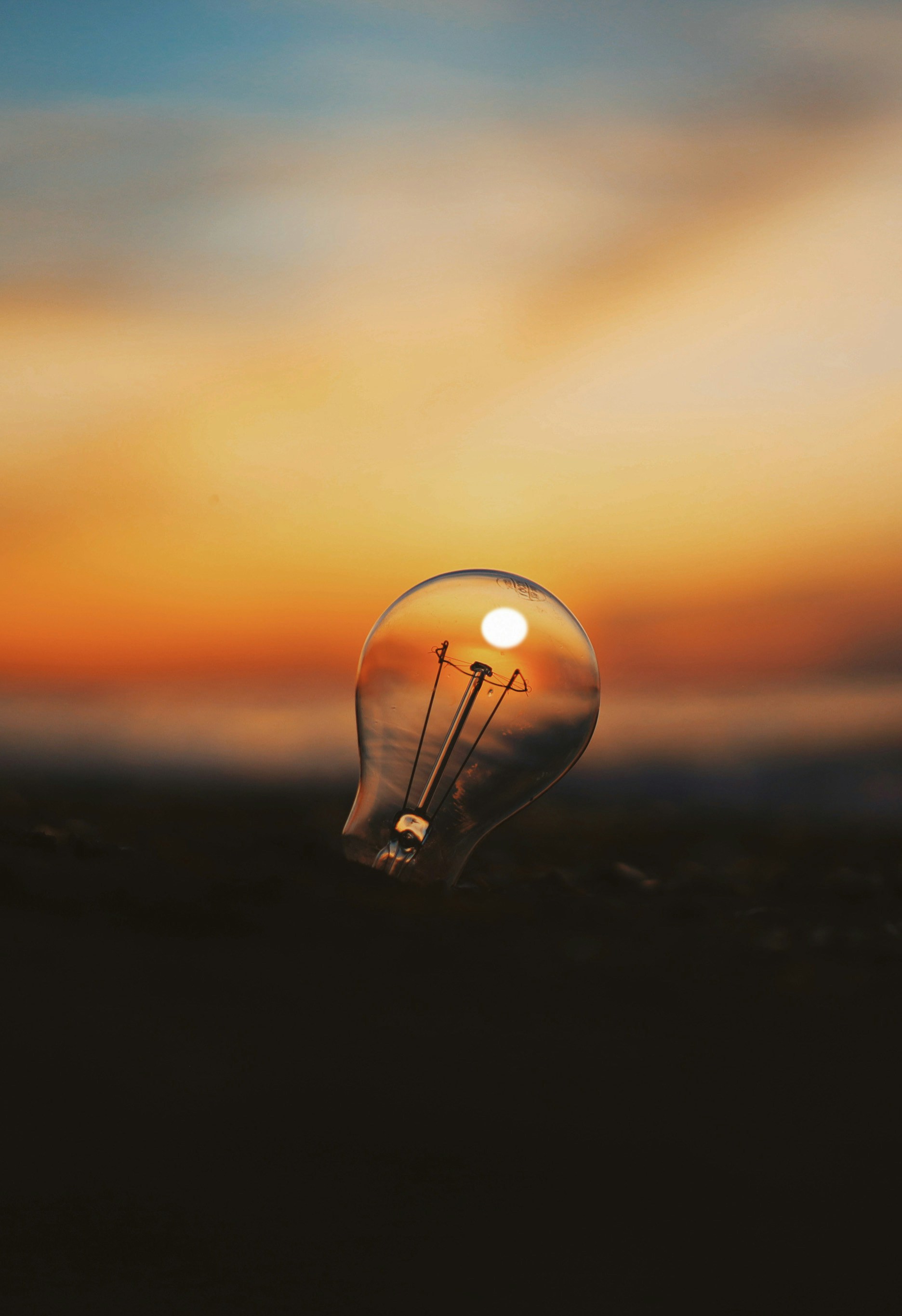 Lightbulb reflecting a sunset over the ocean.