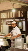 Man in an apron smiling in a food stall