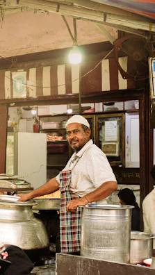 Man in an apron smiling in a food stall