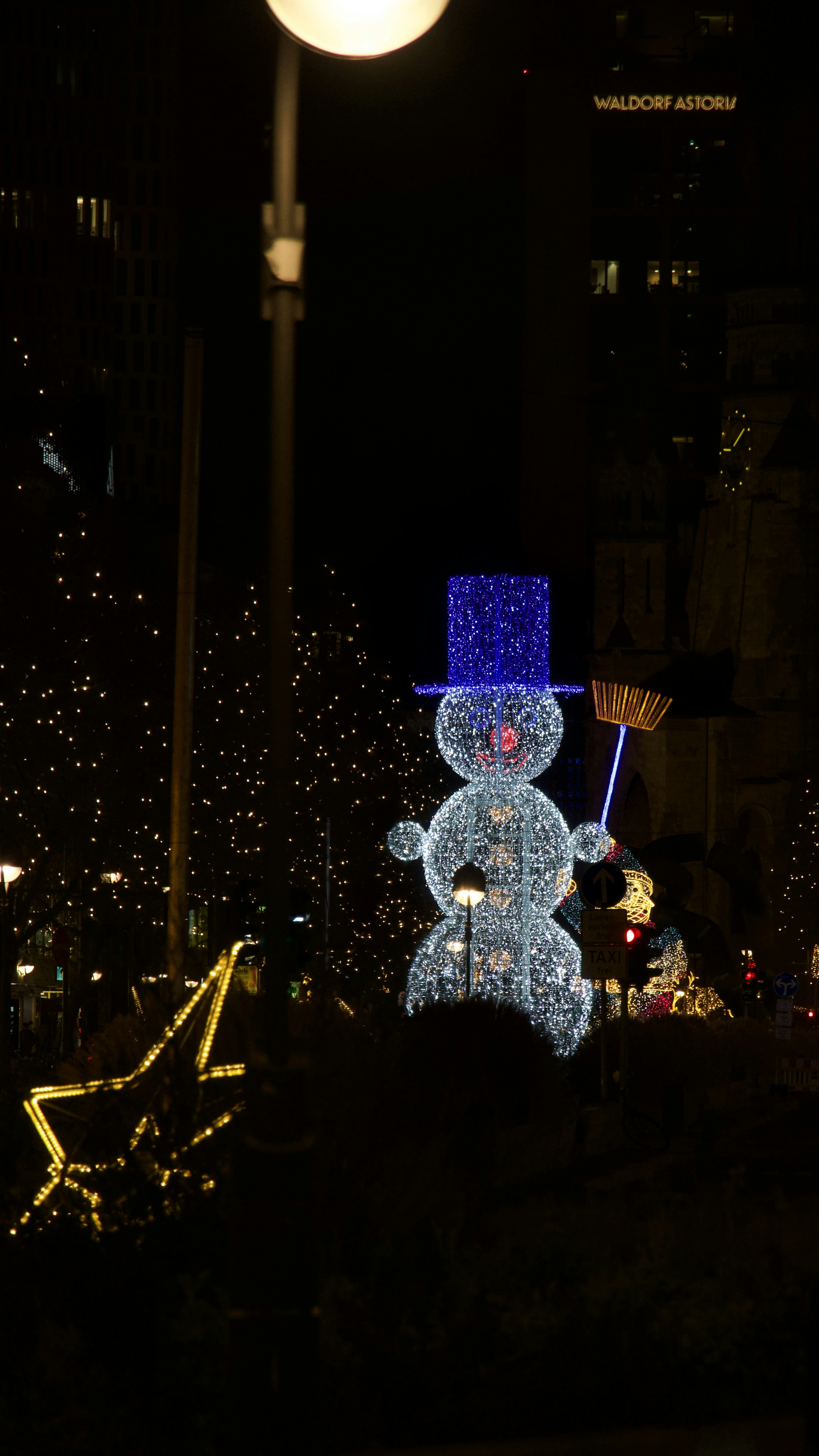 青い帽子とほうきで光る雪だるまの飾り。