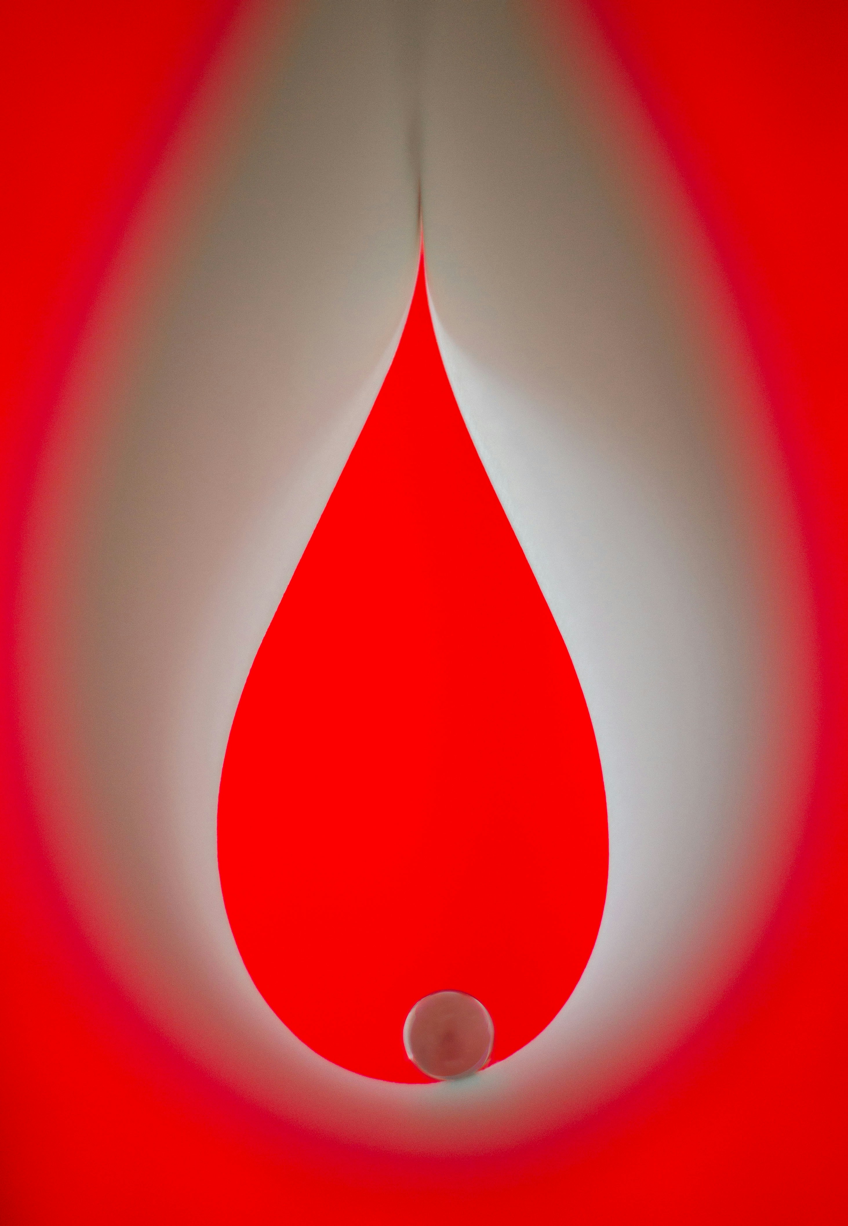 A single red drop against a white and red background