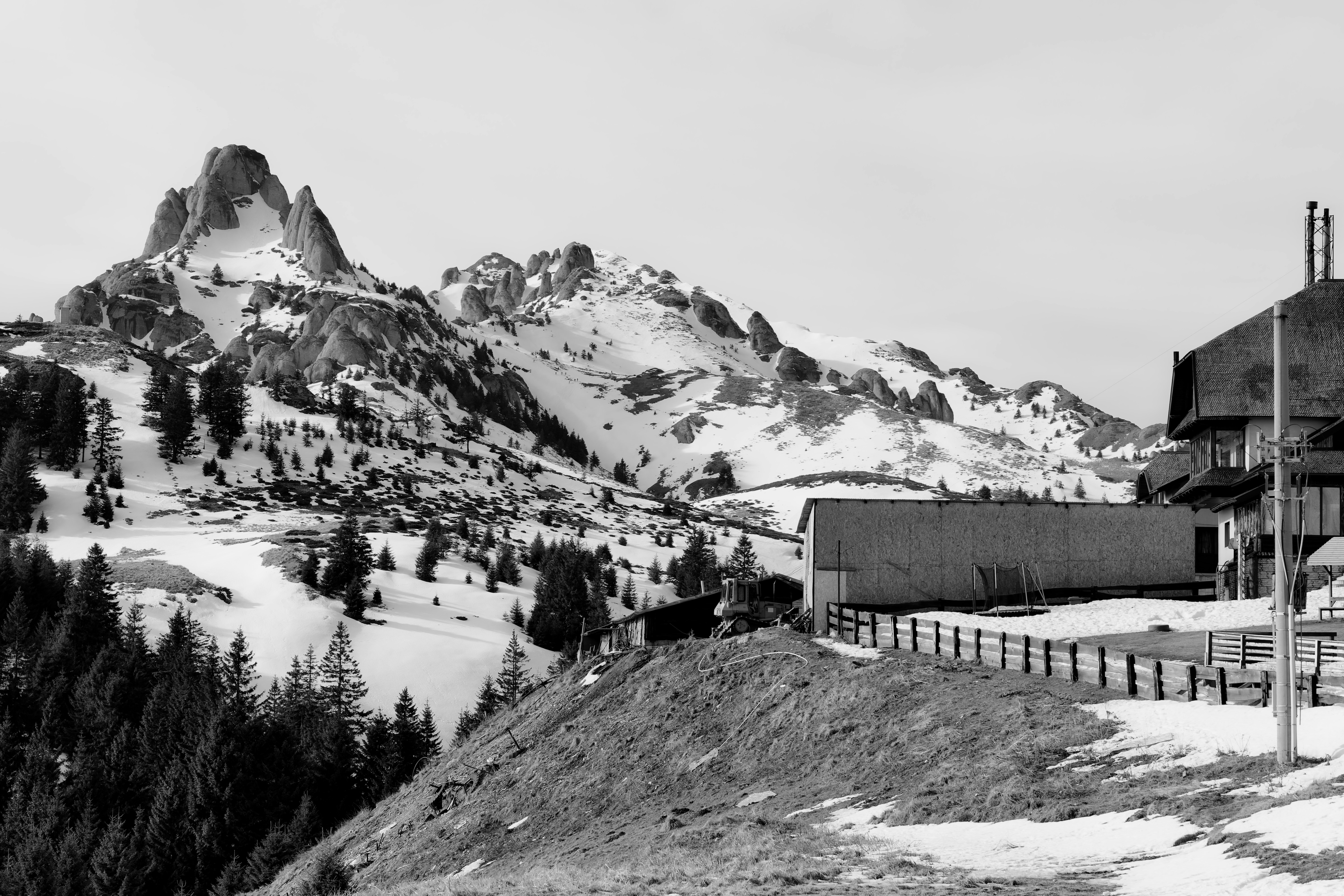 Snowy mountain range with trees and buildings