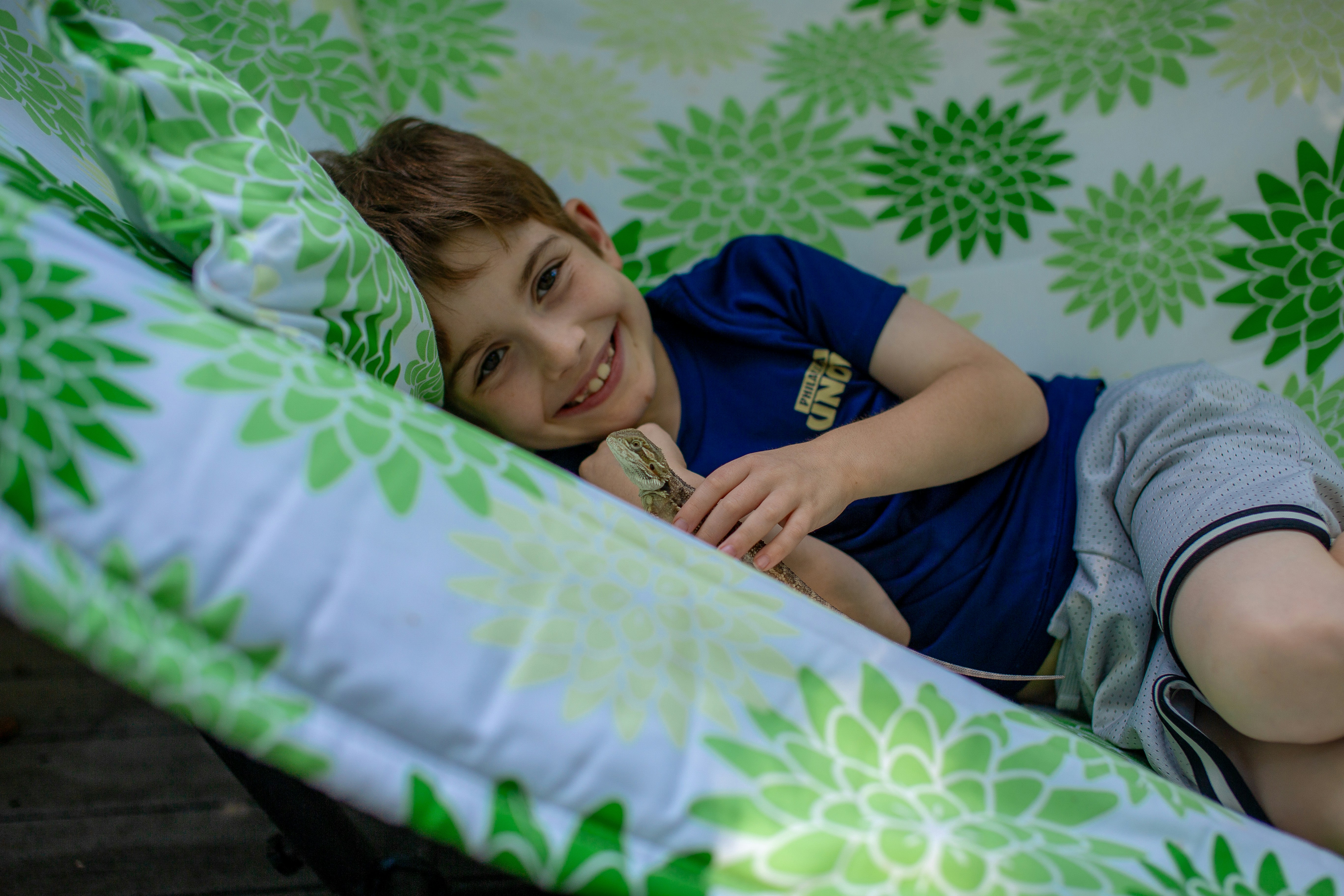 A smiling young boy relaxing in a hammock