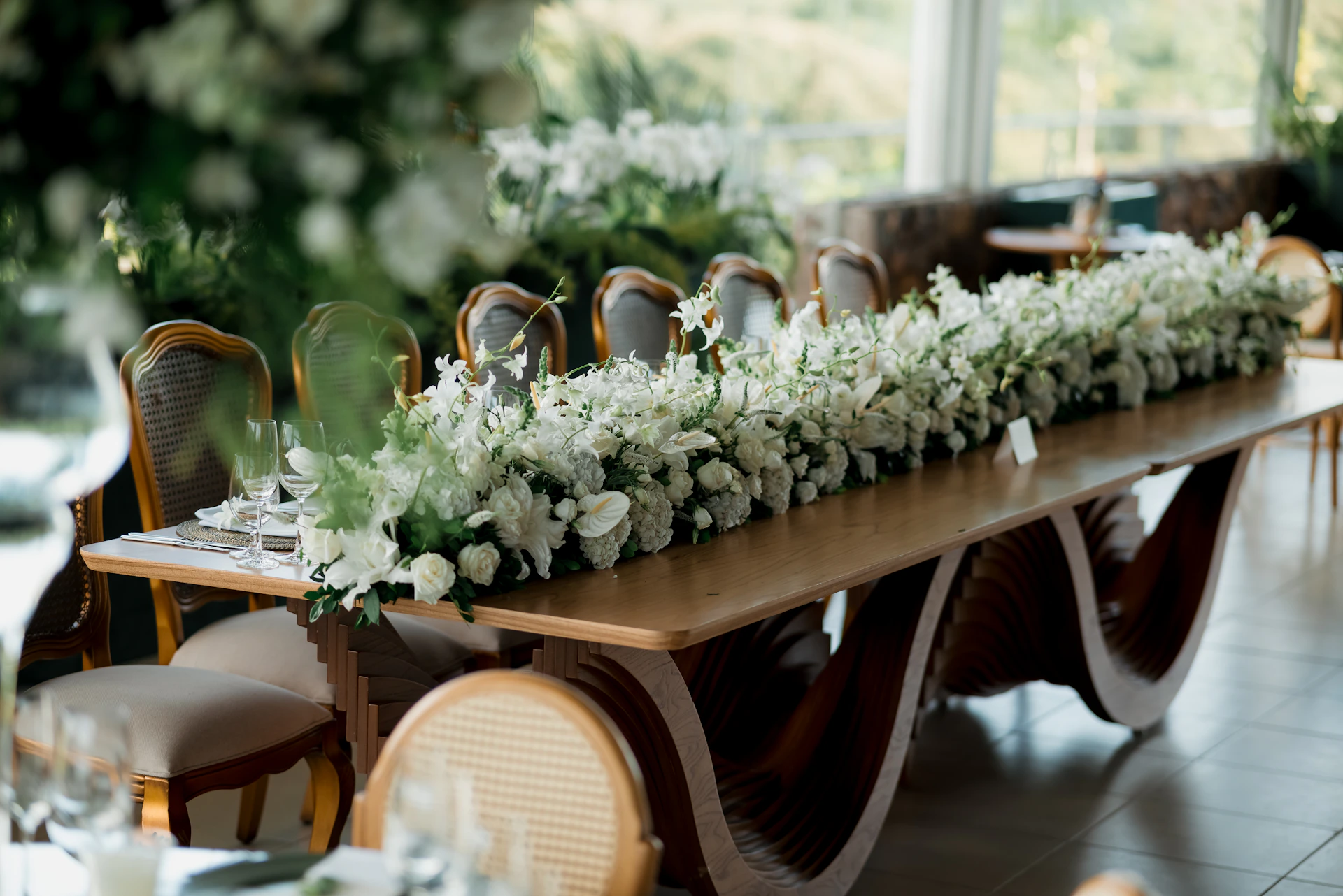 A long wooden table adorned with white flowers