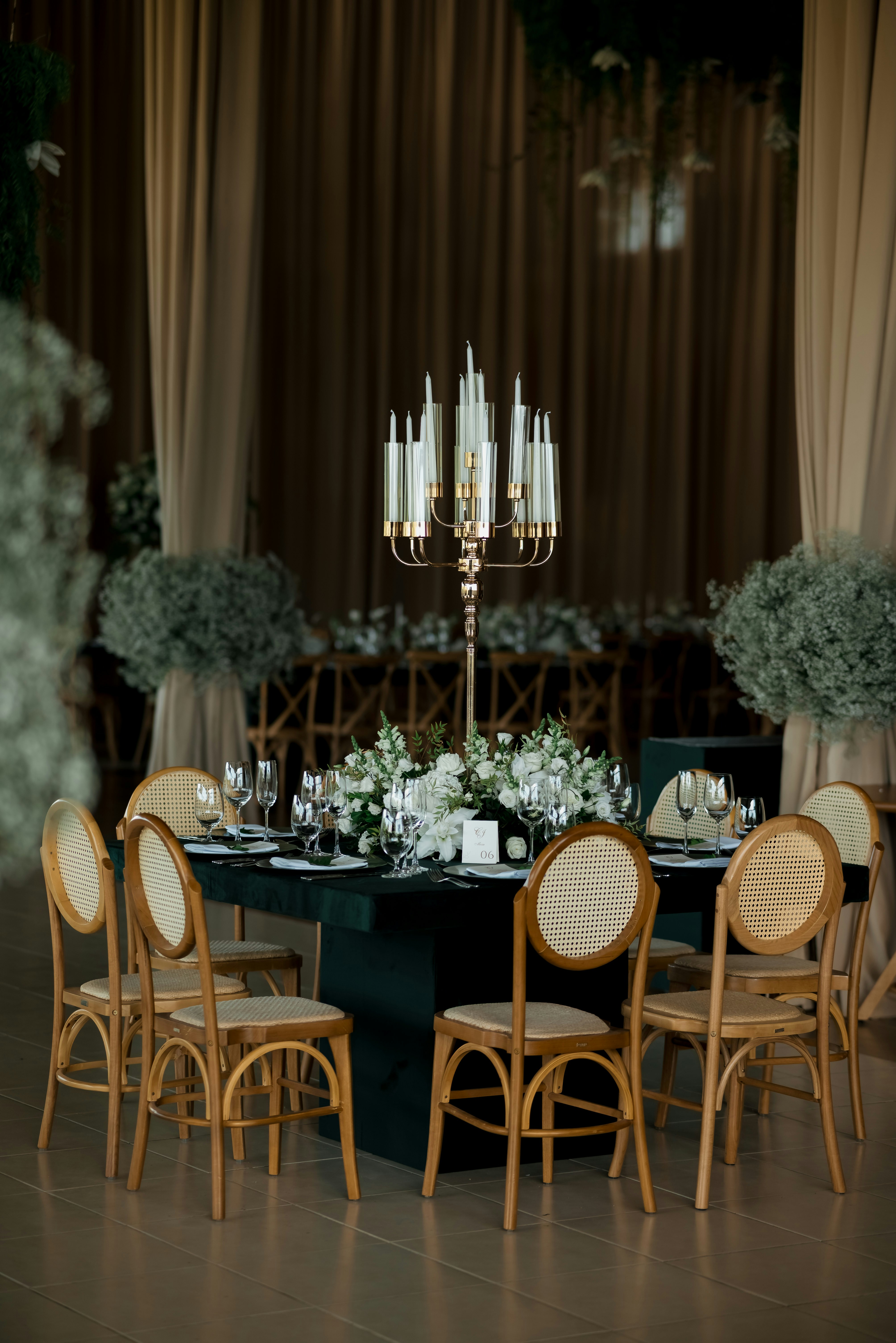 花柄のセンターピースと燭台を備えたエレガントなテーブルセッティング。