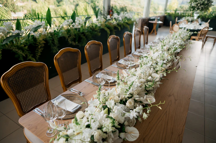 A long table decorated with white flowers for an event.