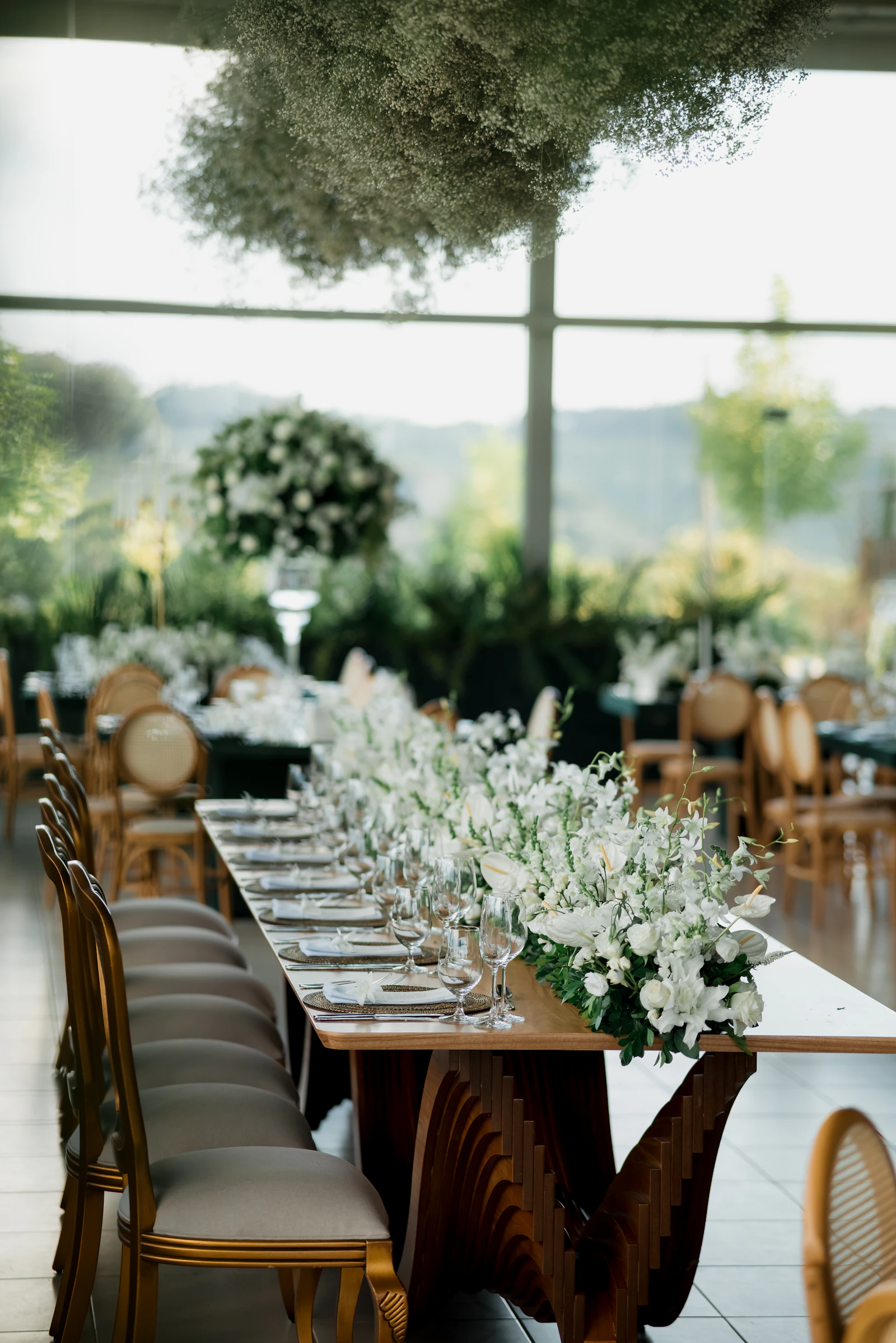 Luxurious wedding table with abundant white flowers, elegant place settings, and refined décor