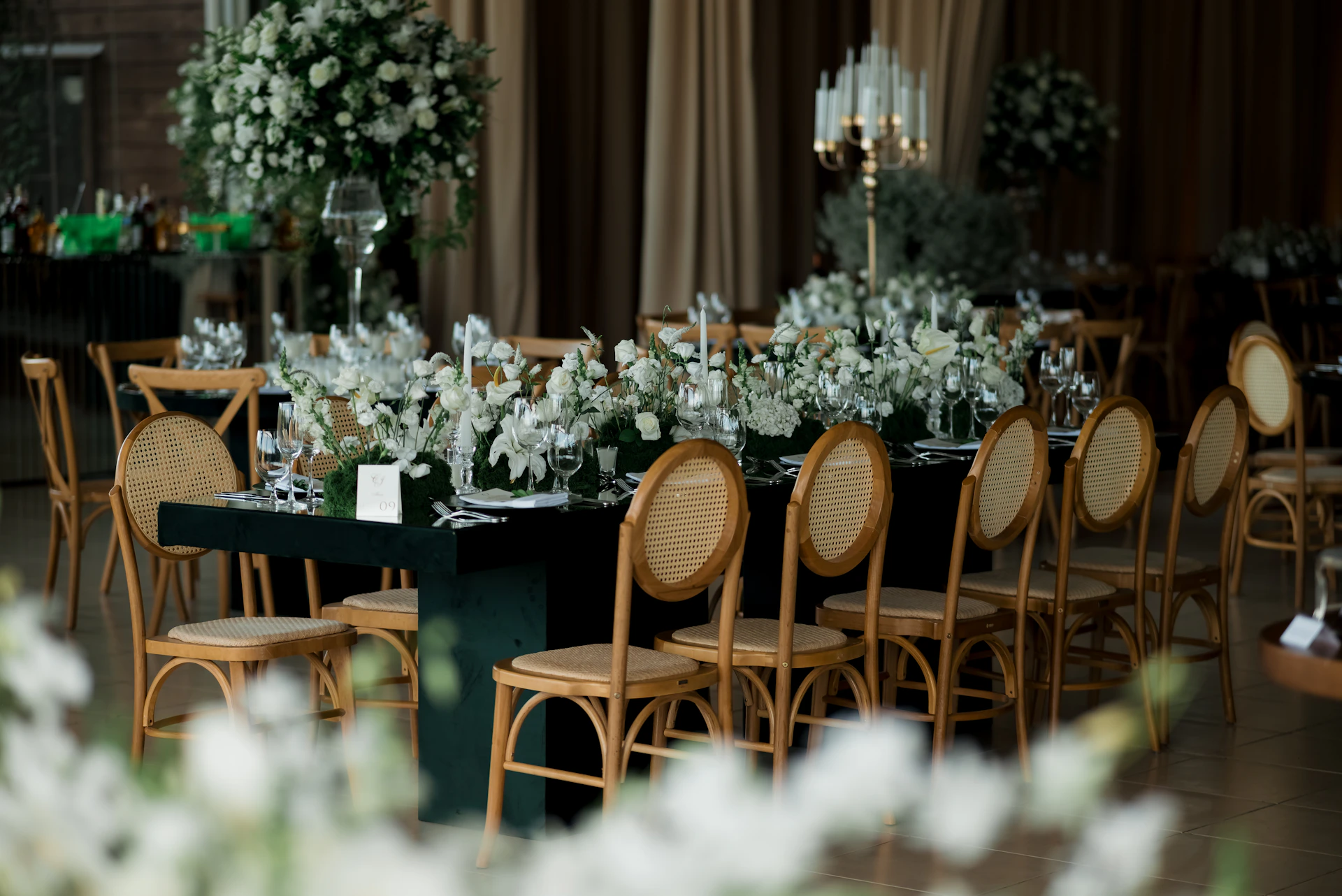 Elegant dining table set with floral arrangements and chairs.